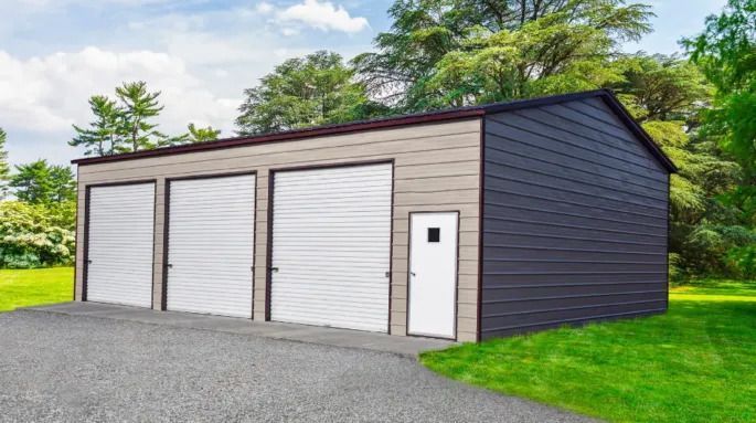 A garage with three garage doors and a door on the side of it.