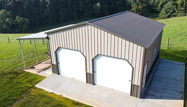 an aerial view of a metal garage with two garage doors and a canopy