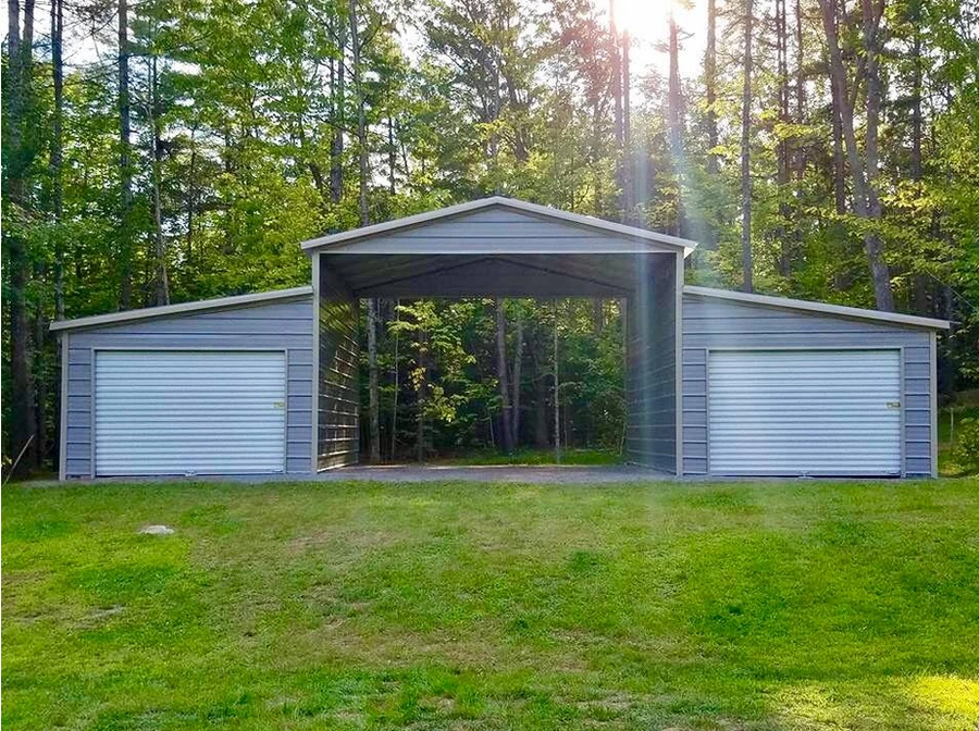 a gray garage with two doors is sitting in the middle of a lush green field