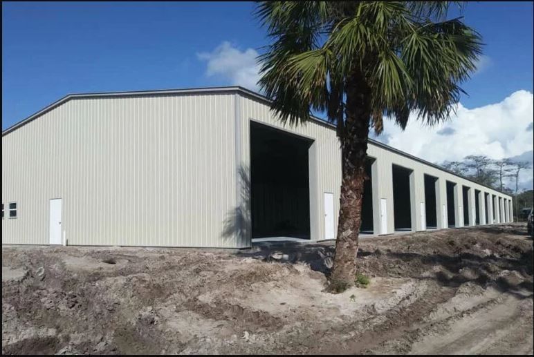 A large metal building with a palm tree in front of it