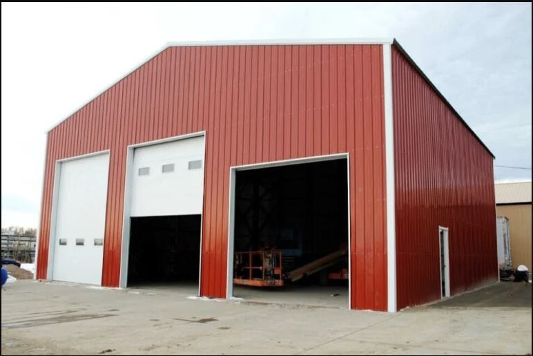 A large red metal building with white doors