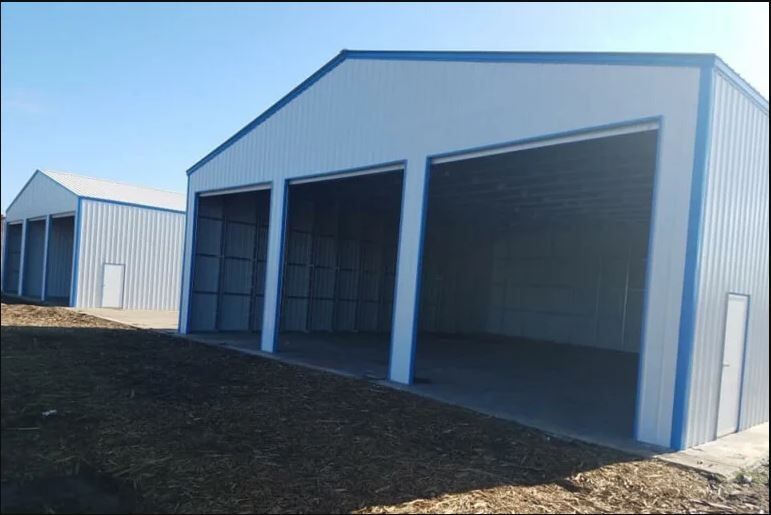 A white and blue metal building with a lot of doors