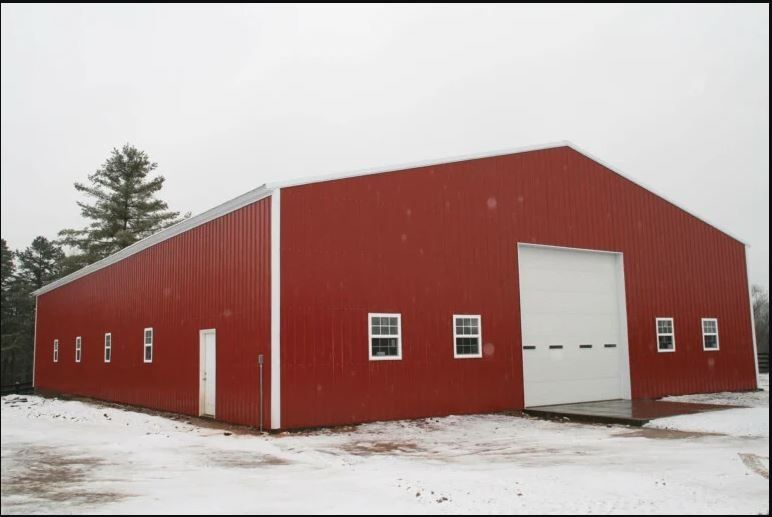 A large red metal building with a white door and windows