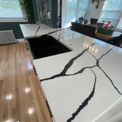 A kitchen with a black and white granite counter top.