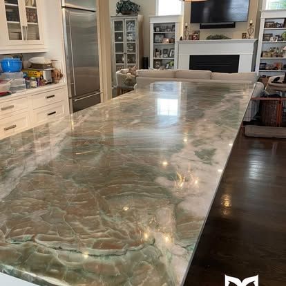 A kitchen with a large marble counter top and a fireplace.