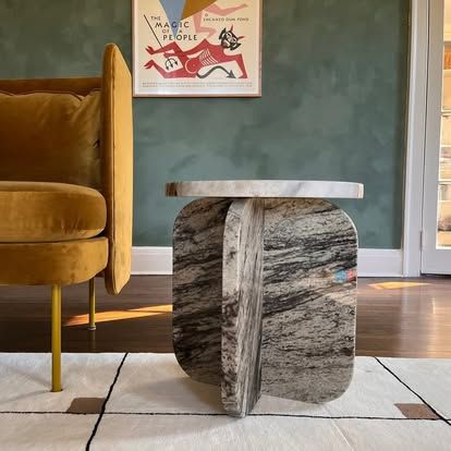 A marble table in a living room next to a yellow chair