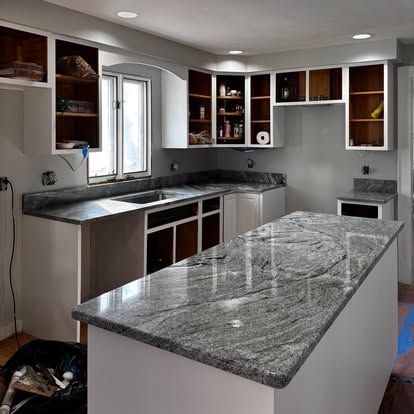 A kitchen with granite counter tops and white cabinets