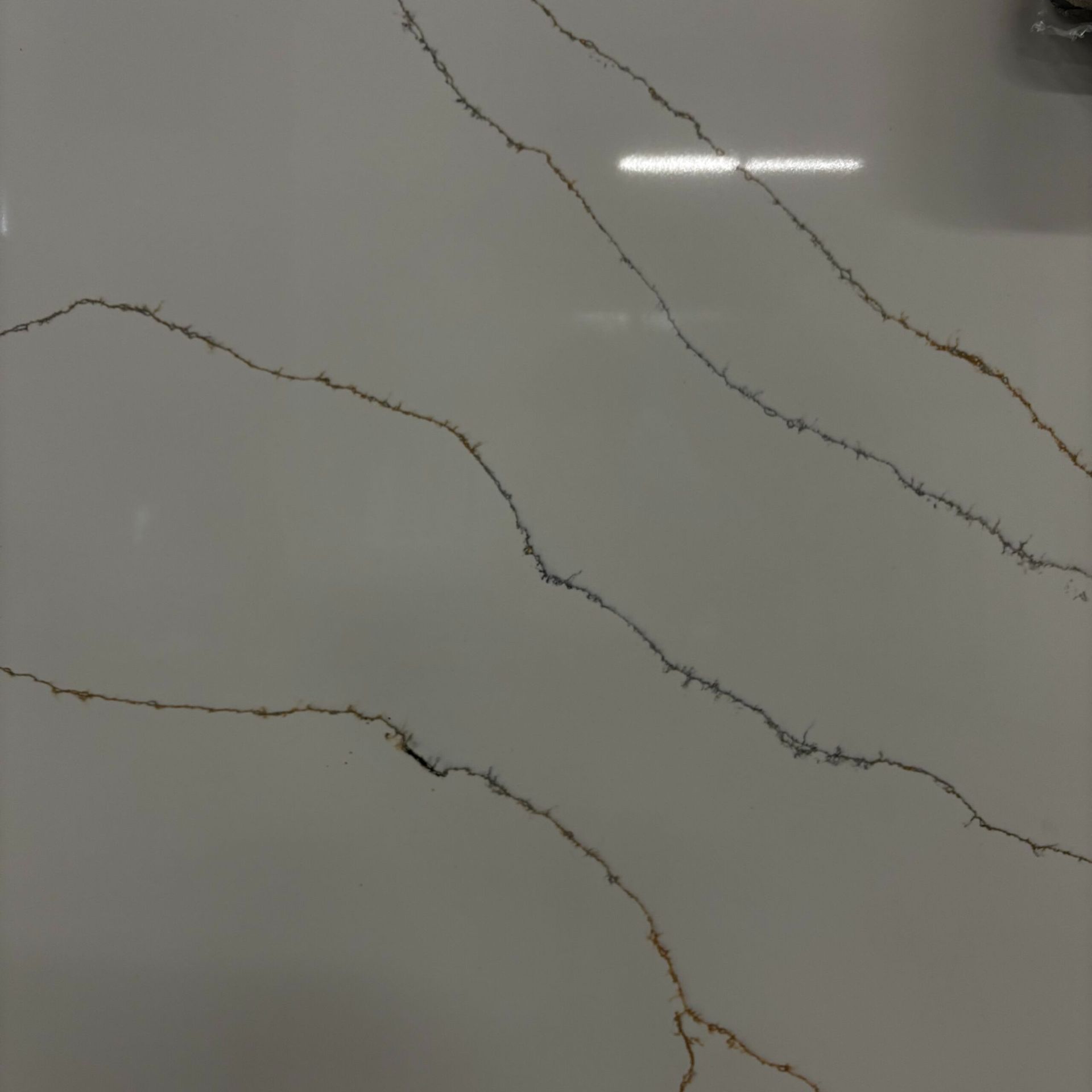 A close up of a white counter top with brown lines.