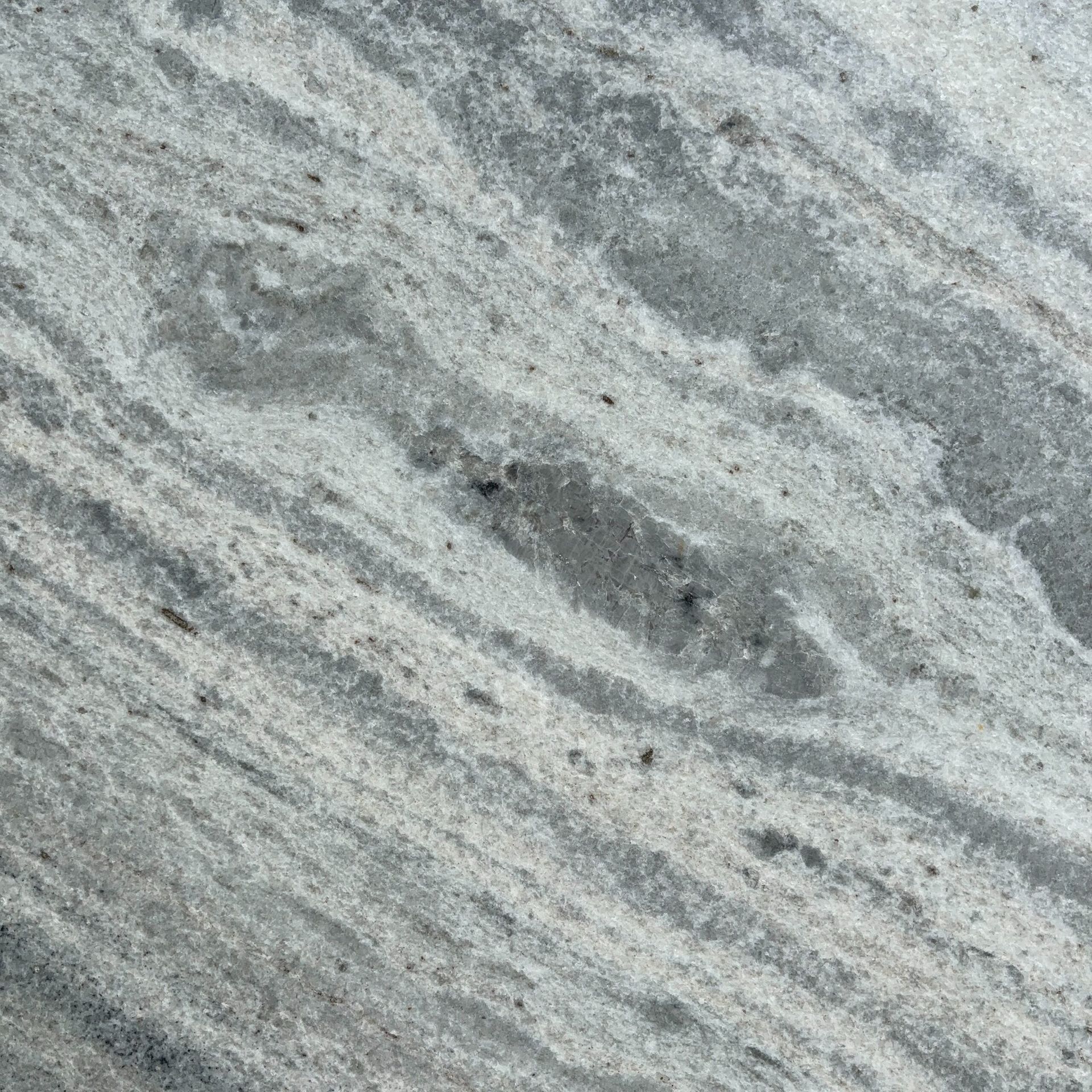 A close up of a gray and white granite counter top.