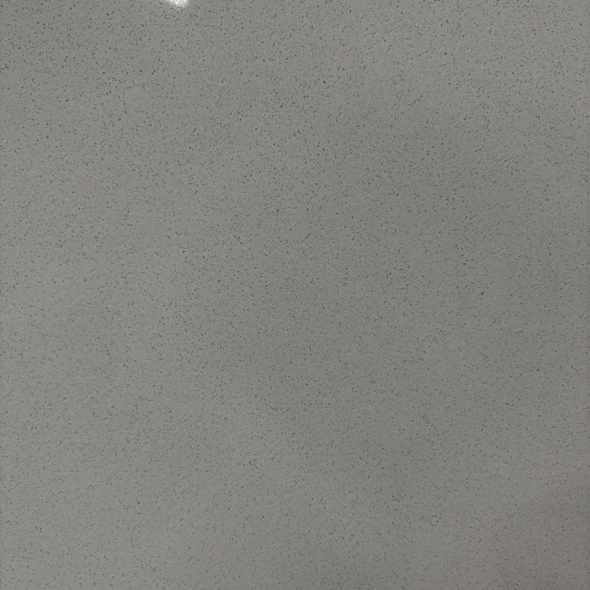 A close up of a white tile with small dots on it