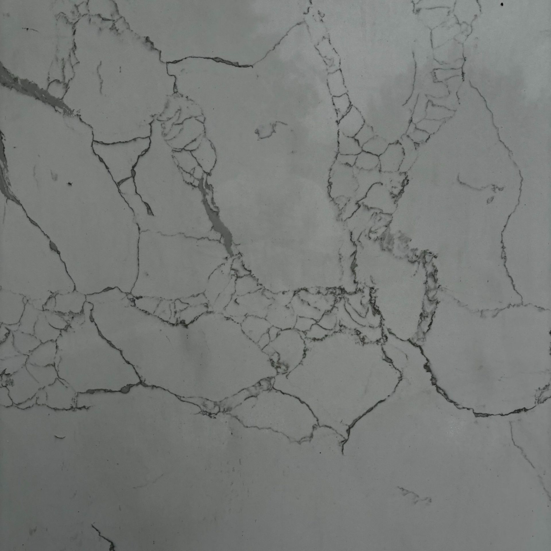 A close up of a white marble texture with a few cracks