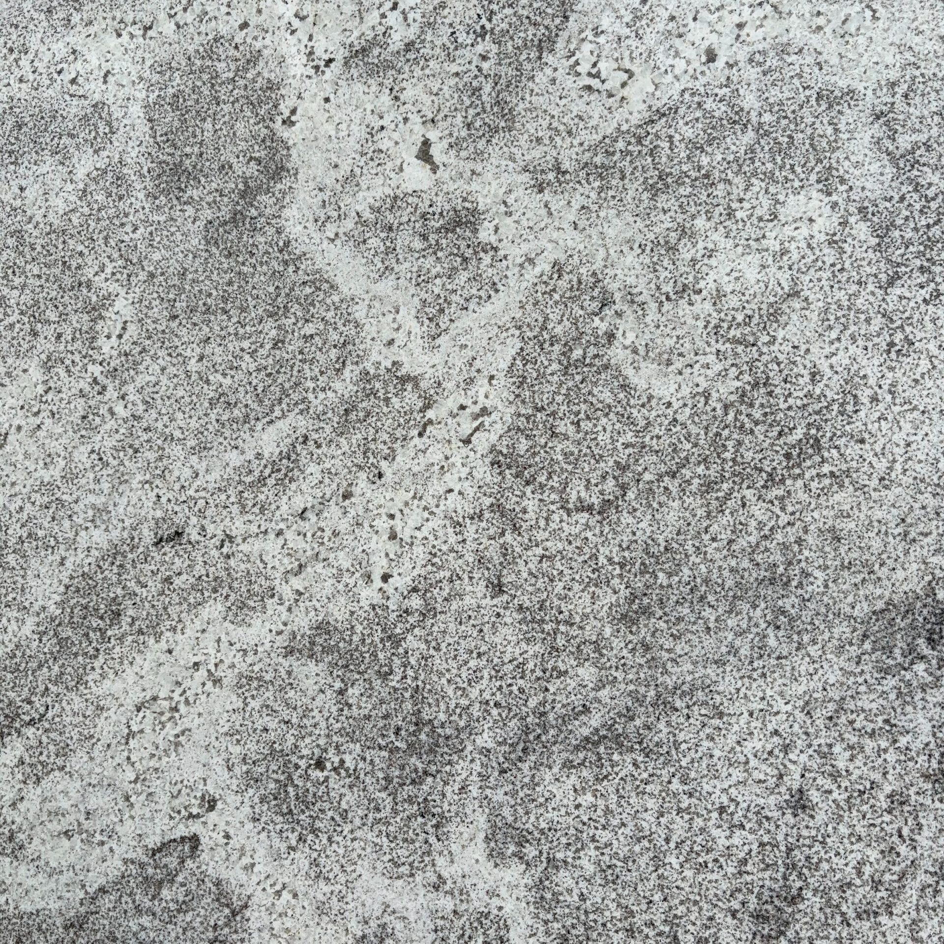 A close up of a gray and white granite counter top.