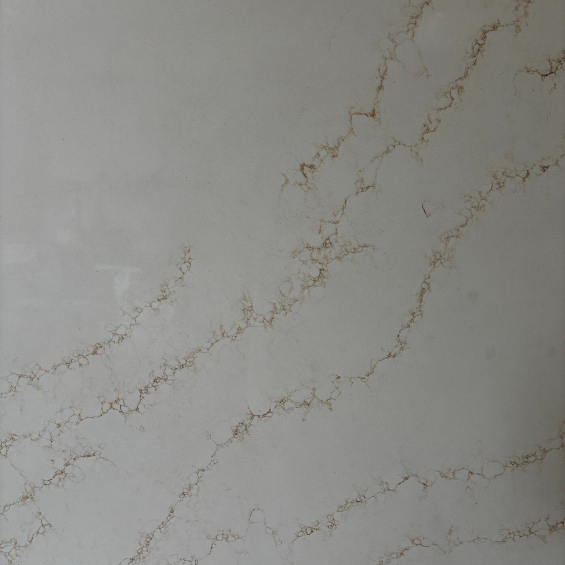 A close up of a white marble counter top with brown veins.
