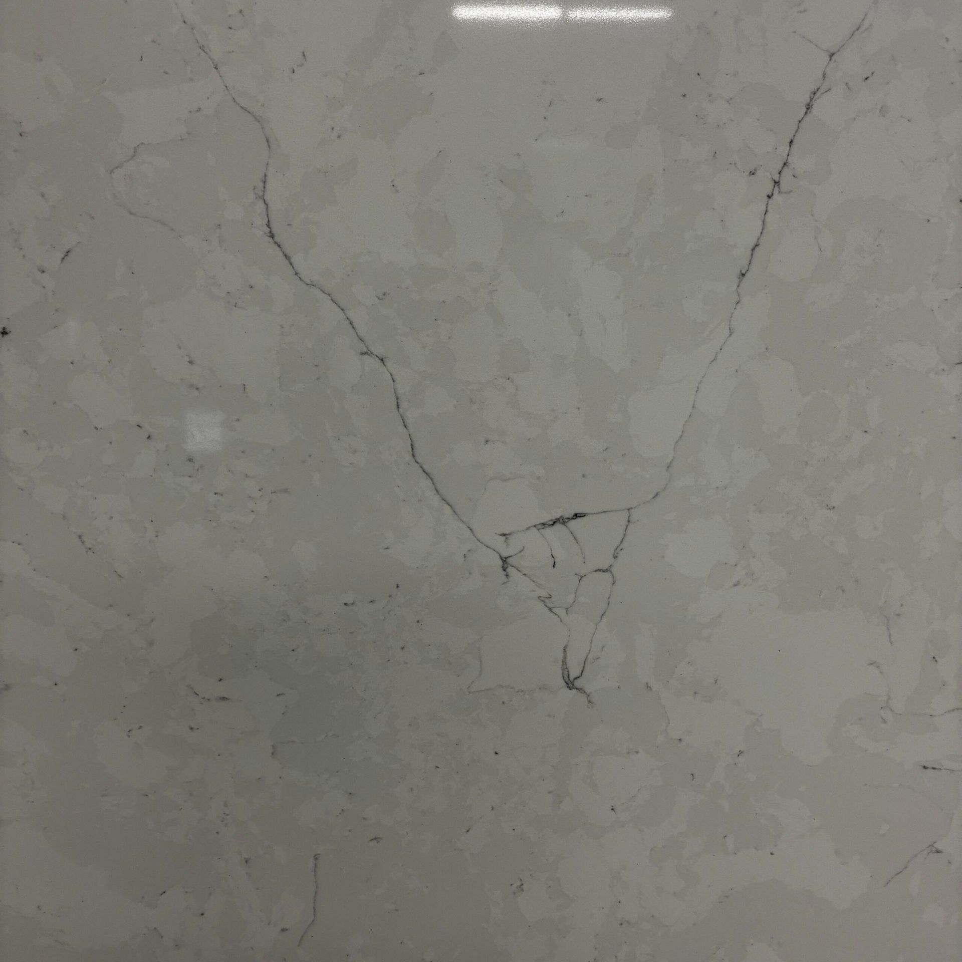 A close up of a white tile with cracks in it.