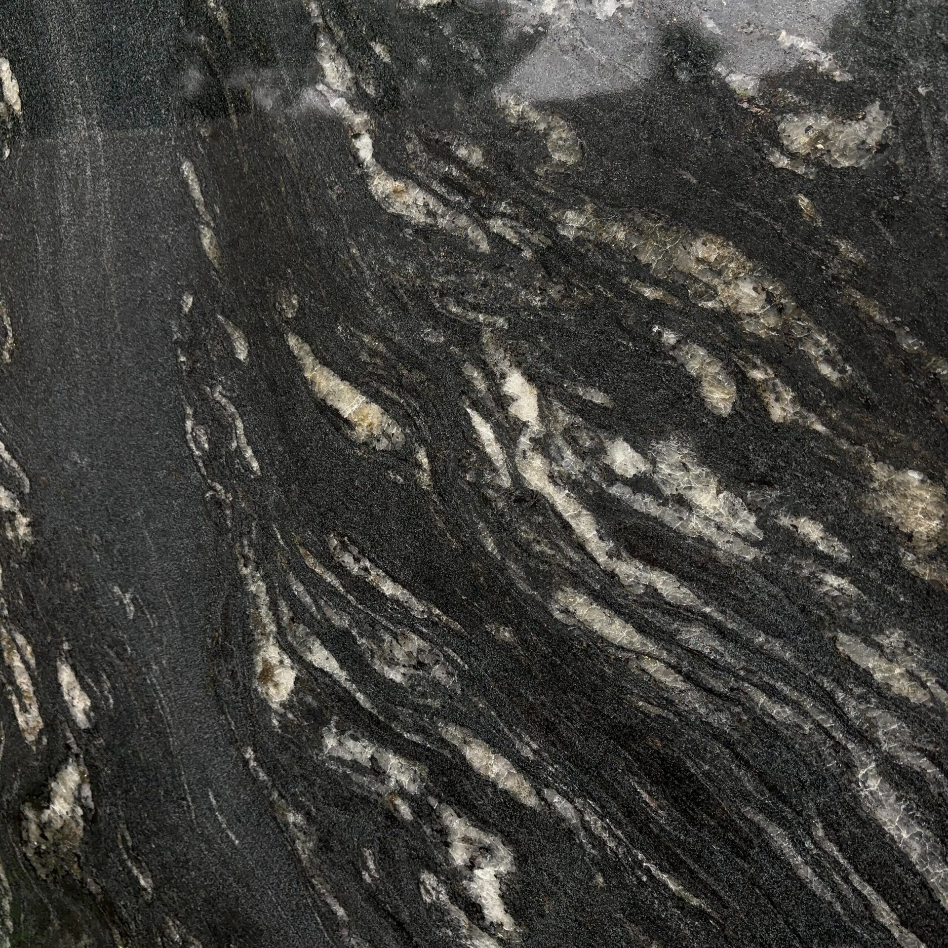 A close up of a black granite counter top with white spots.