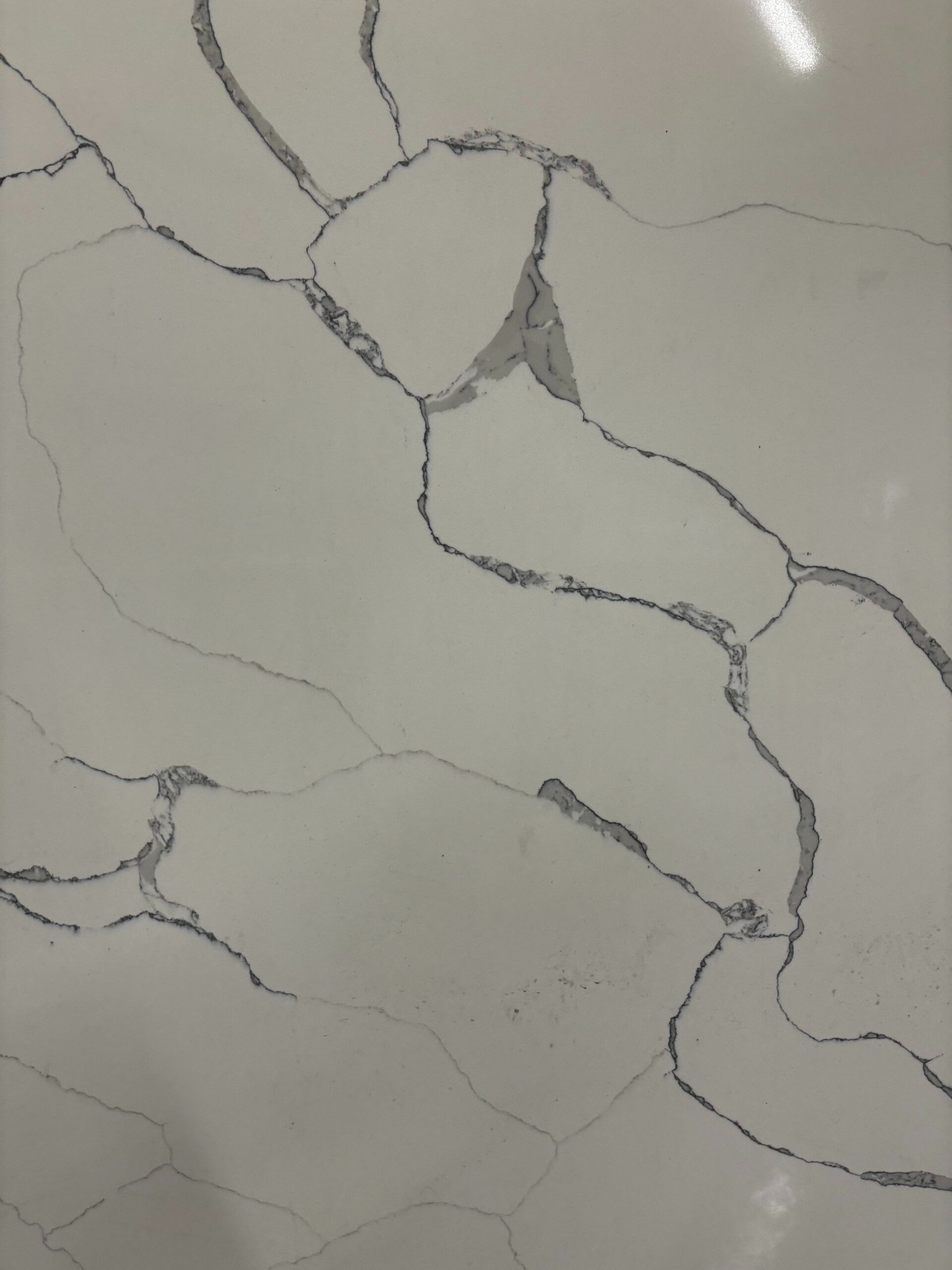 A large white slab of marble is being lifted by a crane.