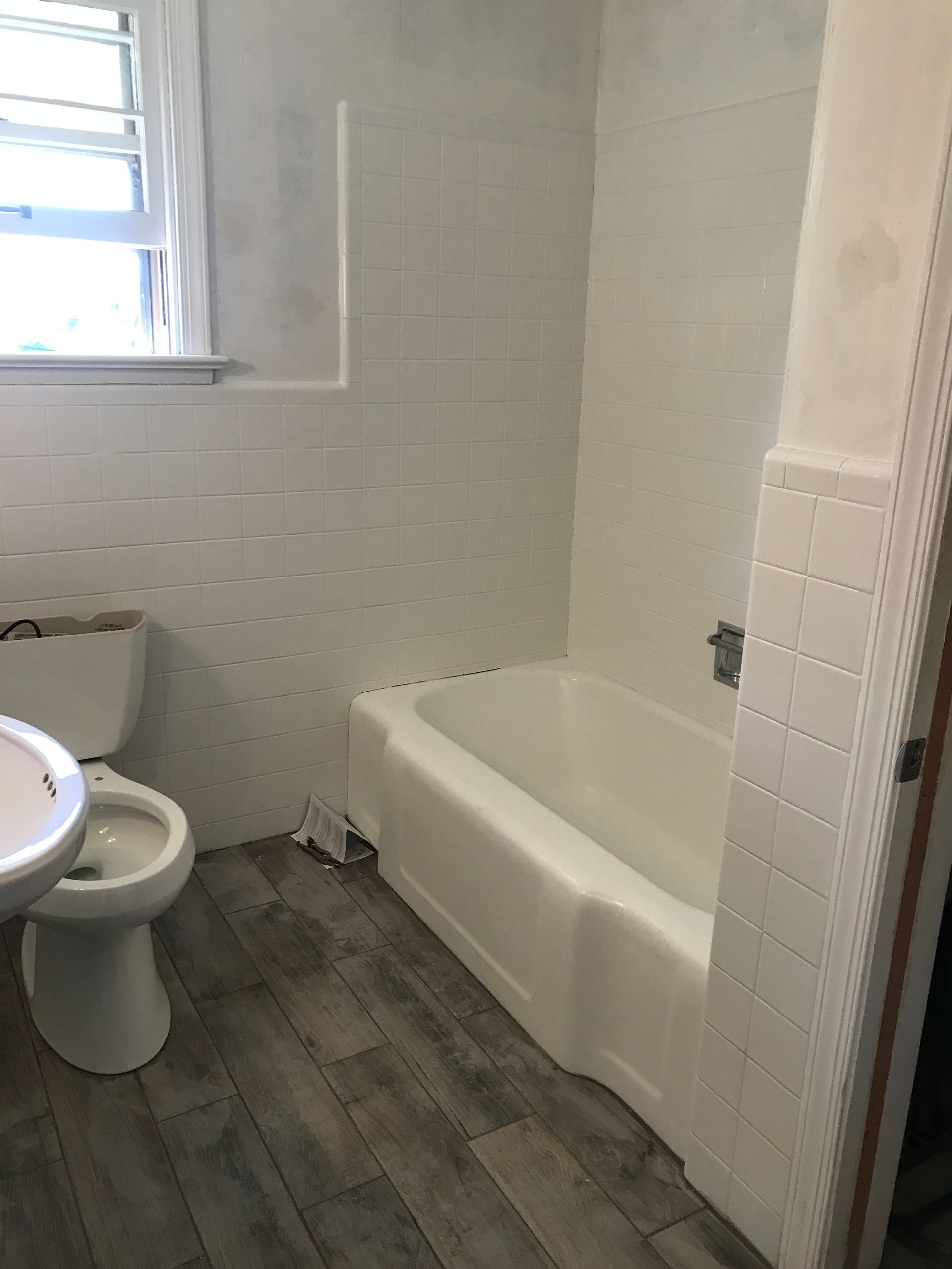 A bathroom with a toilet, sink and bathtub