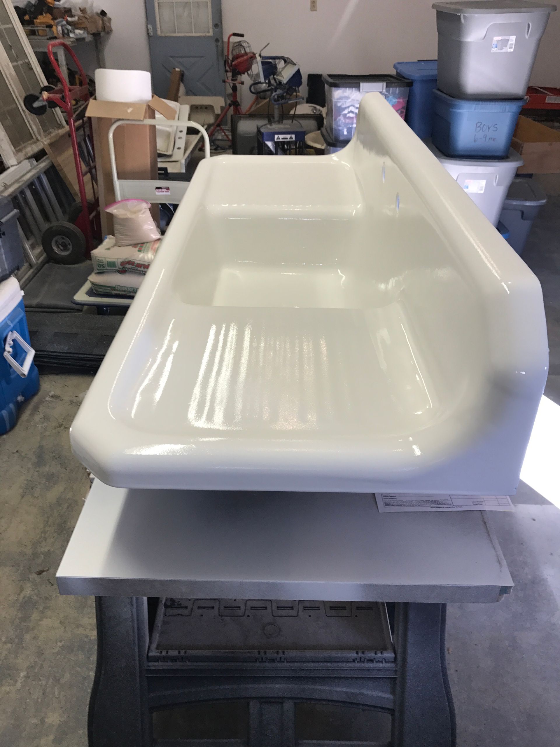 A white sink is sitting on top of a white table