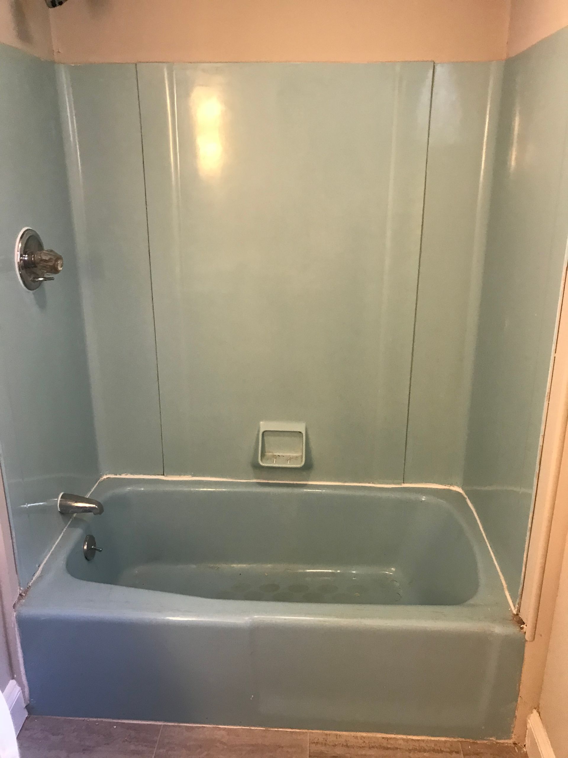 A blue bathtub is sitting in a bathroom next to a shower