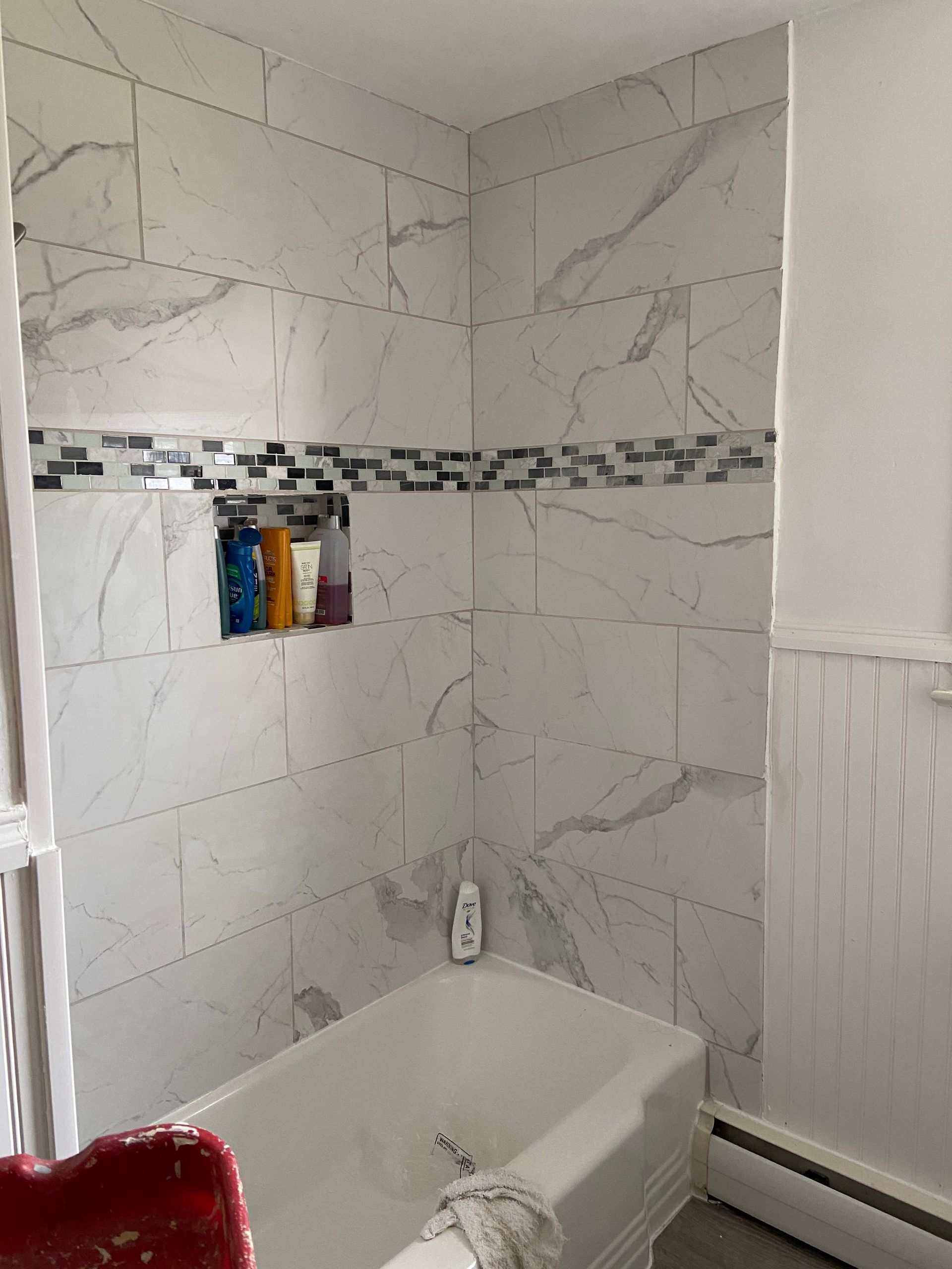 A bathroom with marble tiles and a bathtub