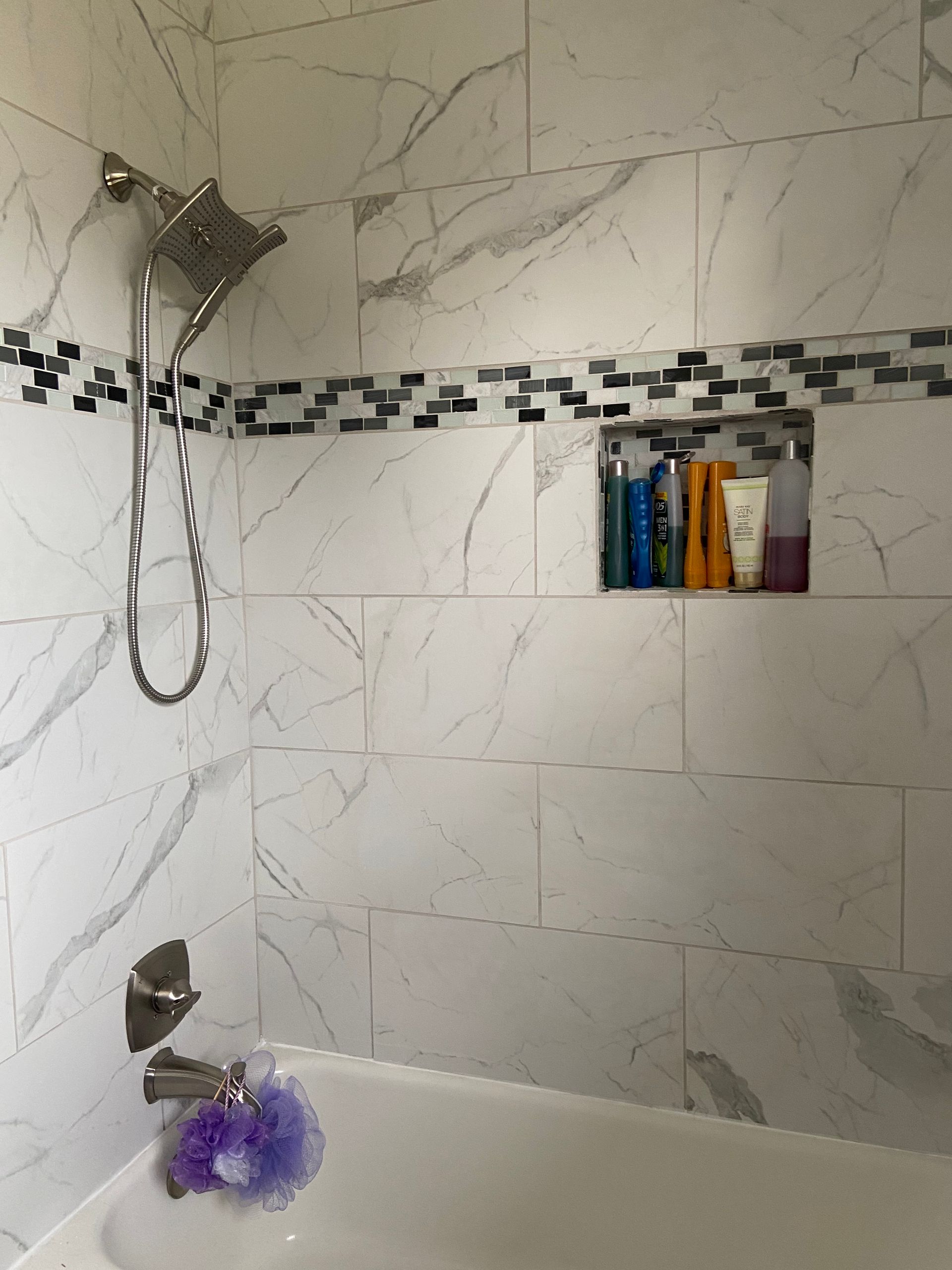 A bathtub with a shower head and a sponge in it