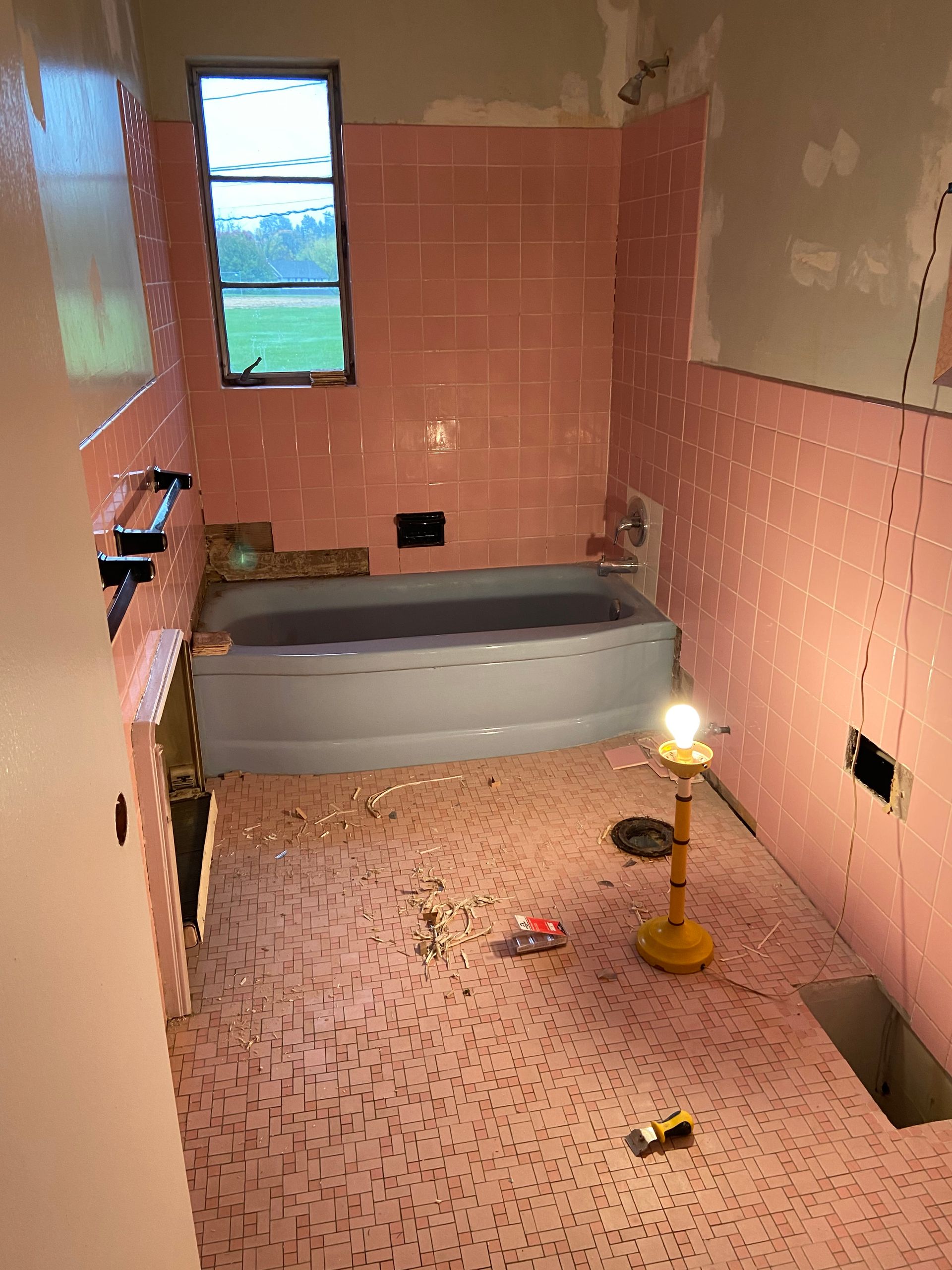 A bathroom with pink tiles and a bathtub
