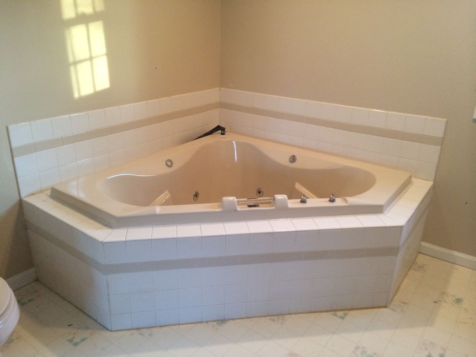 A bathroom with a jacuzzi tub in the corner