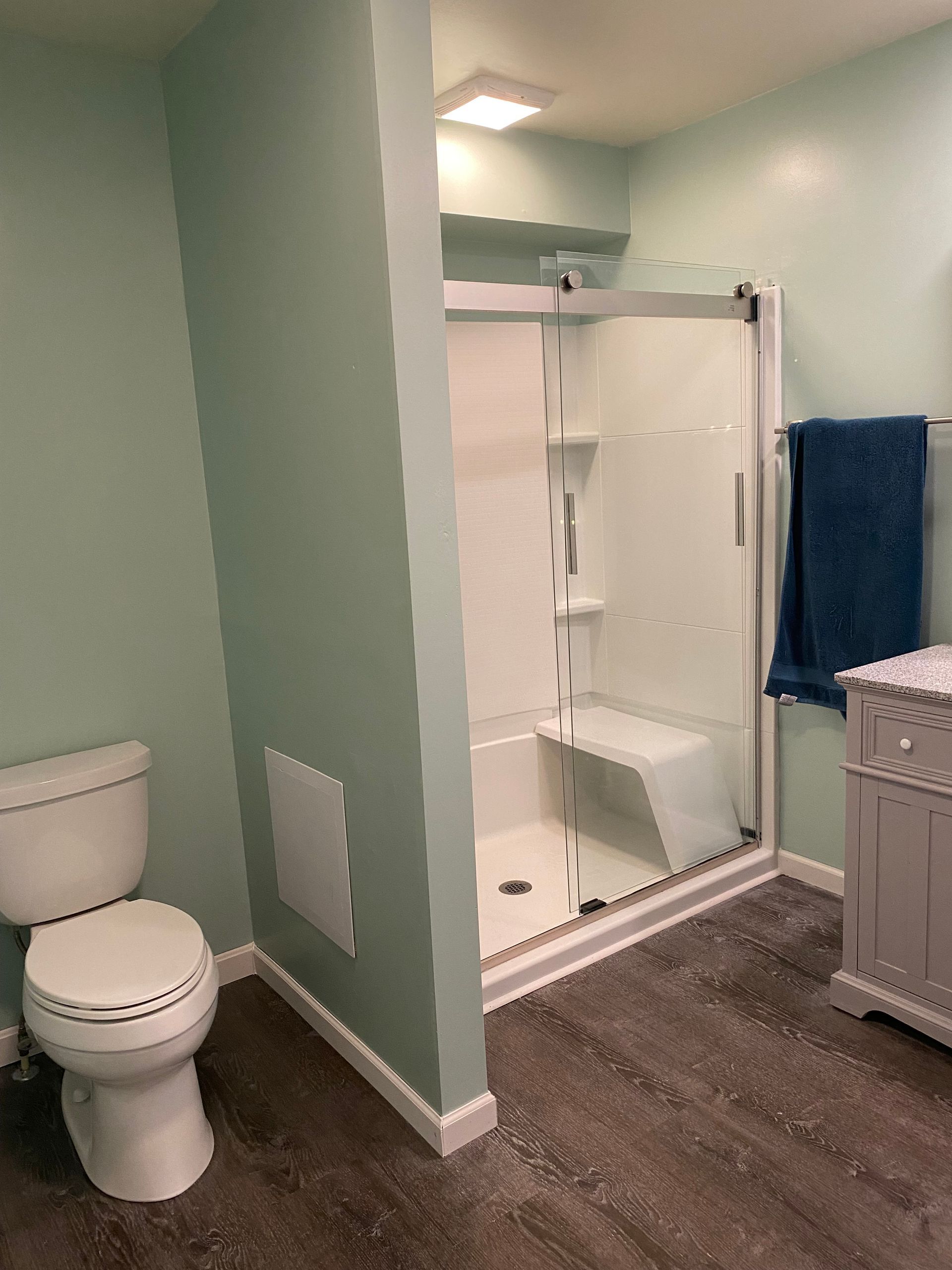 A bathroom with a toilet, shower and sink