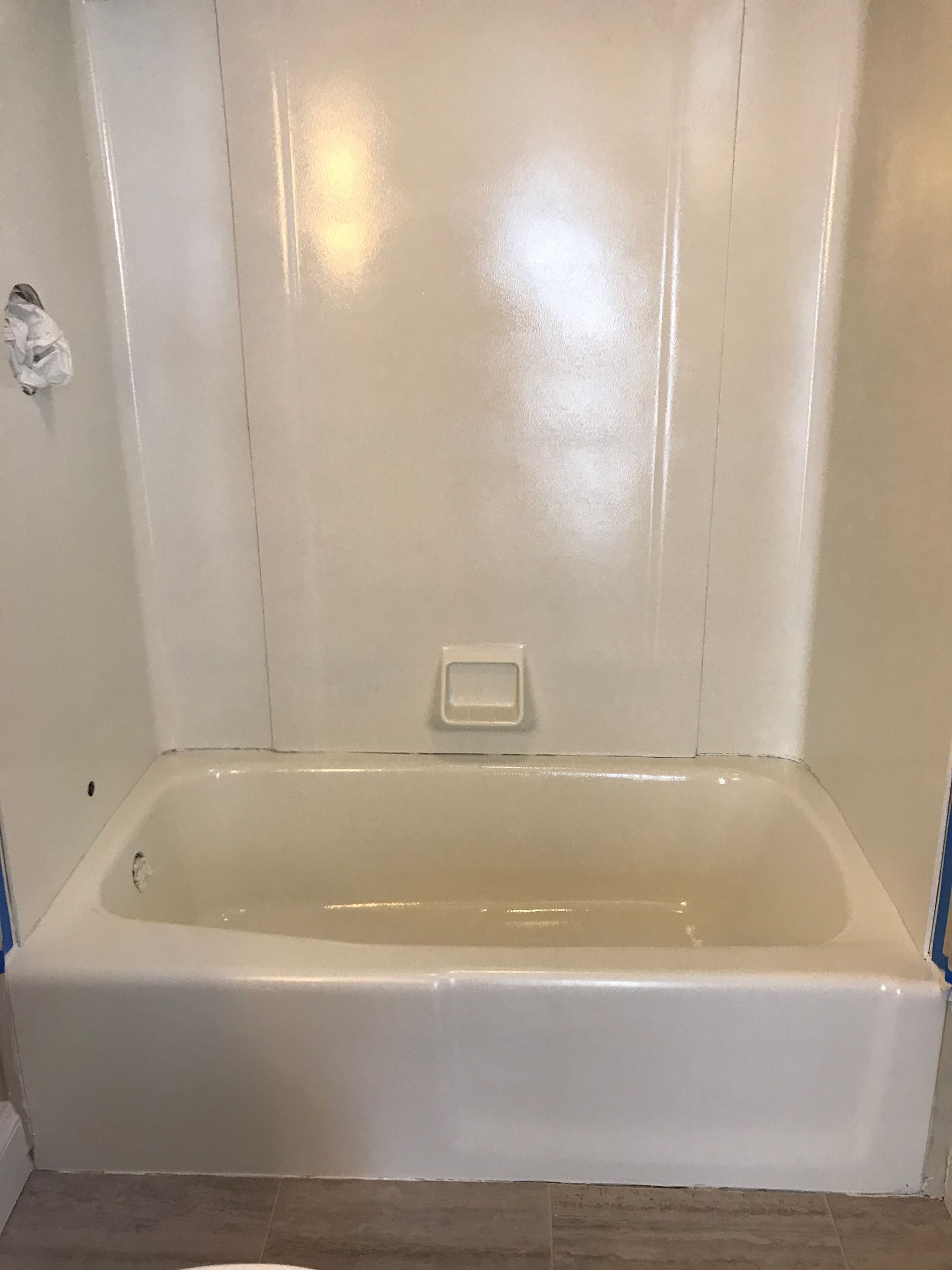A white bathtub is sitting in a bathroom next to a shower