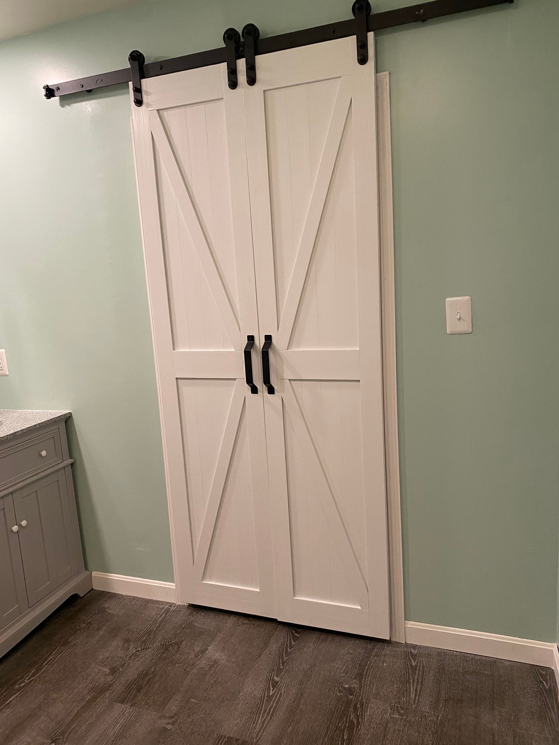 A white barn door is hanging on a wall in a room