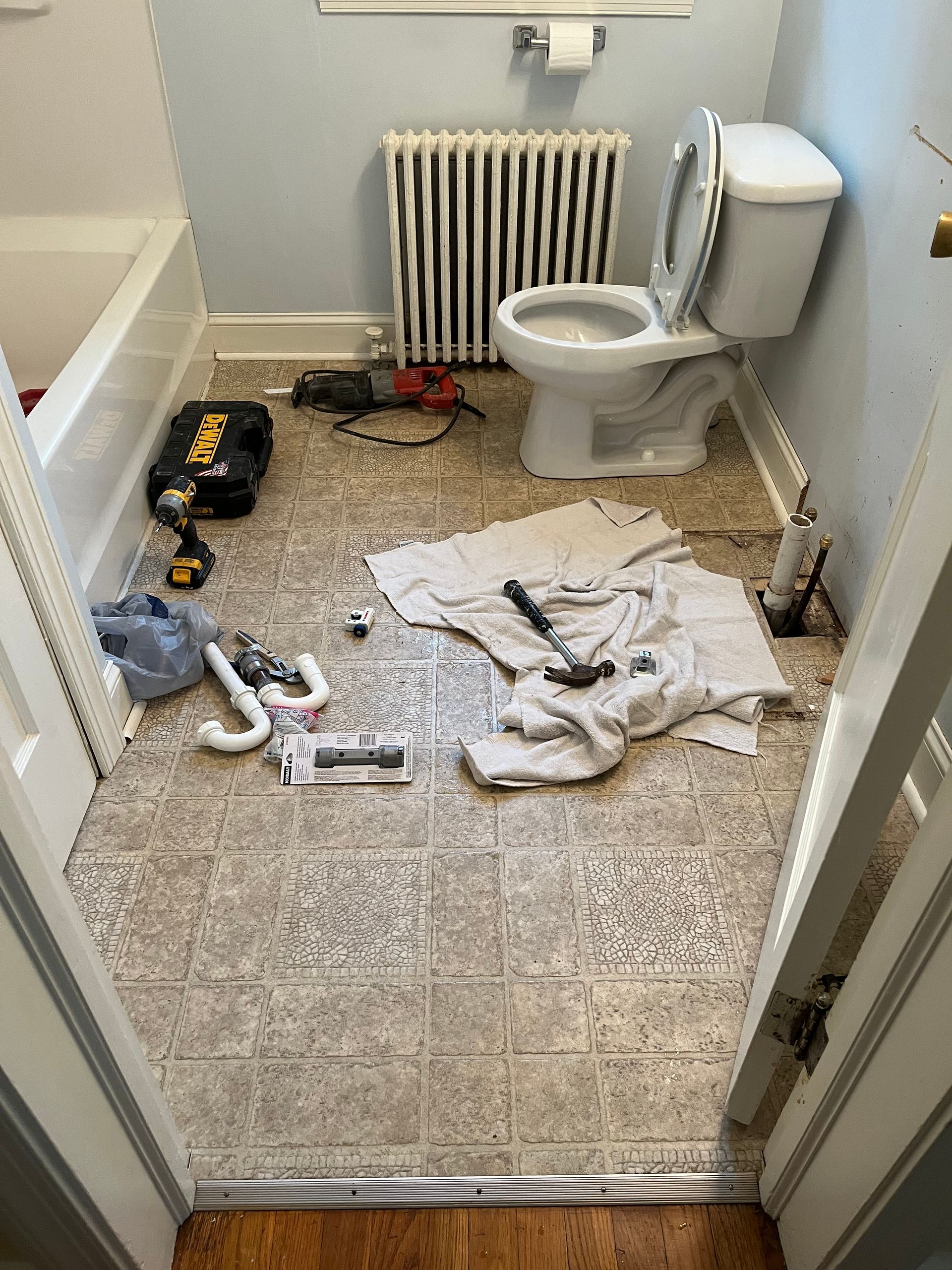 A bathroom with a toilet and a radiator on the floor