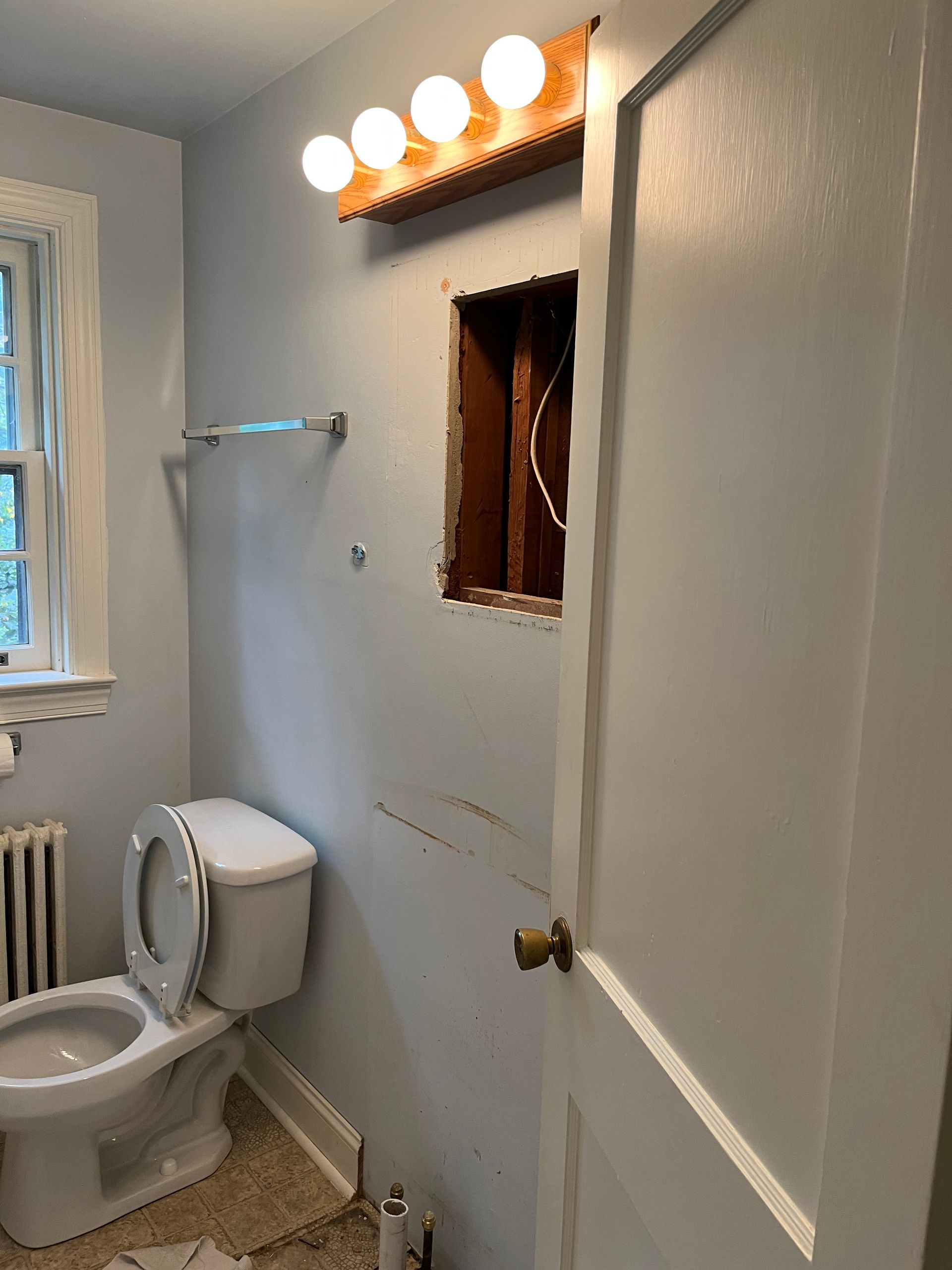 A bathroom with a toilet, sink and window