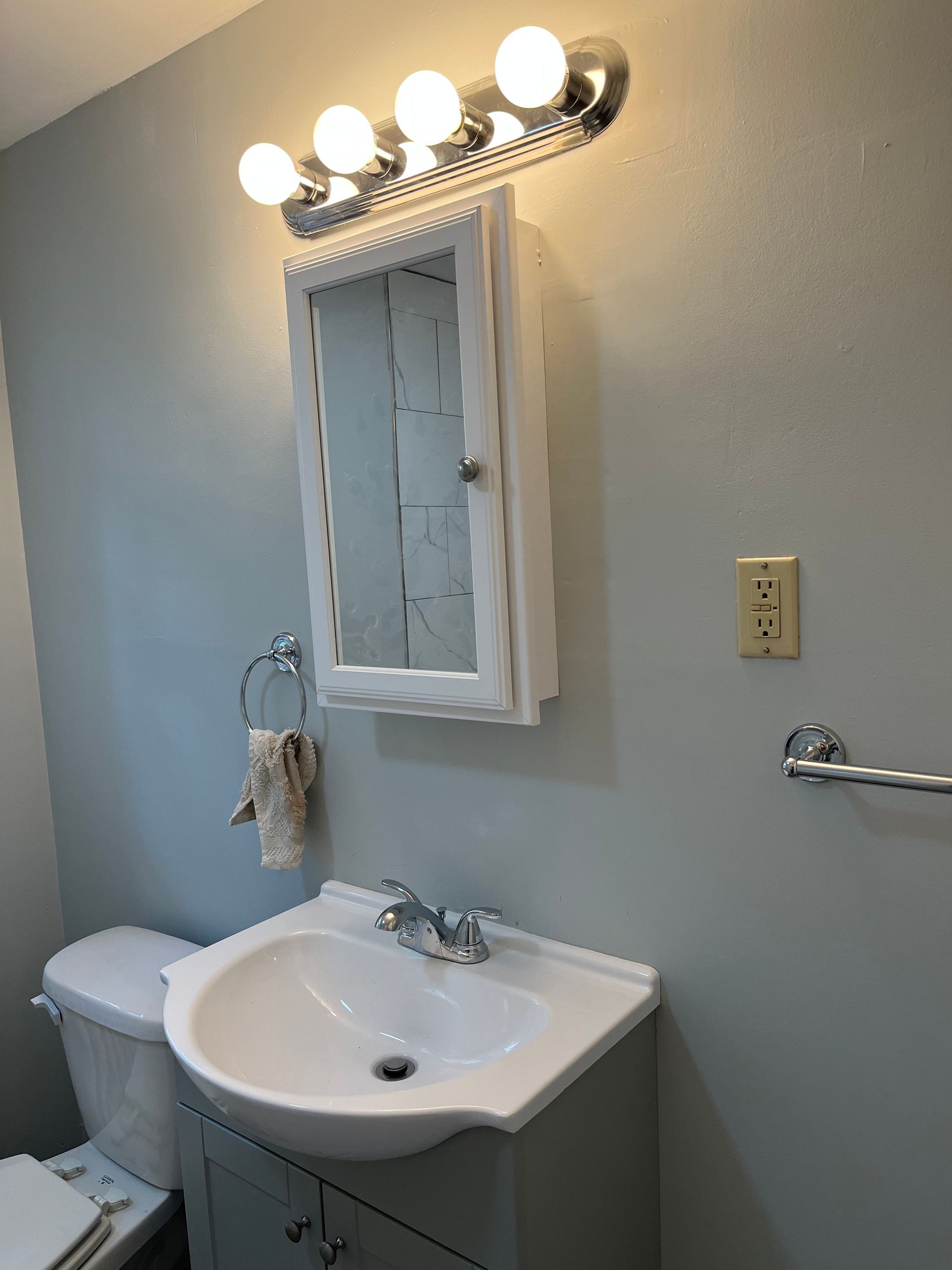 A bathroom with a sink, toilet and mirror