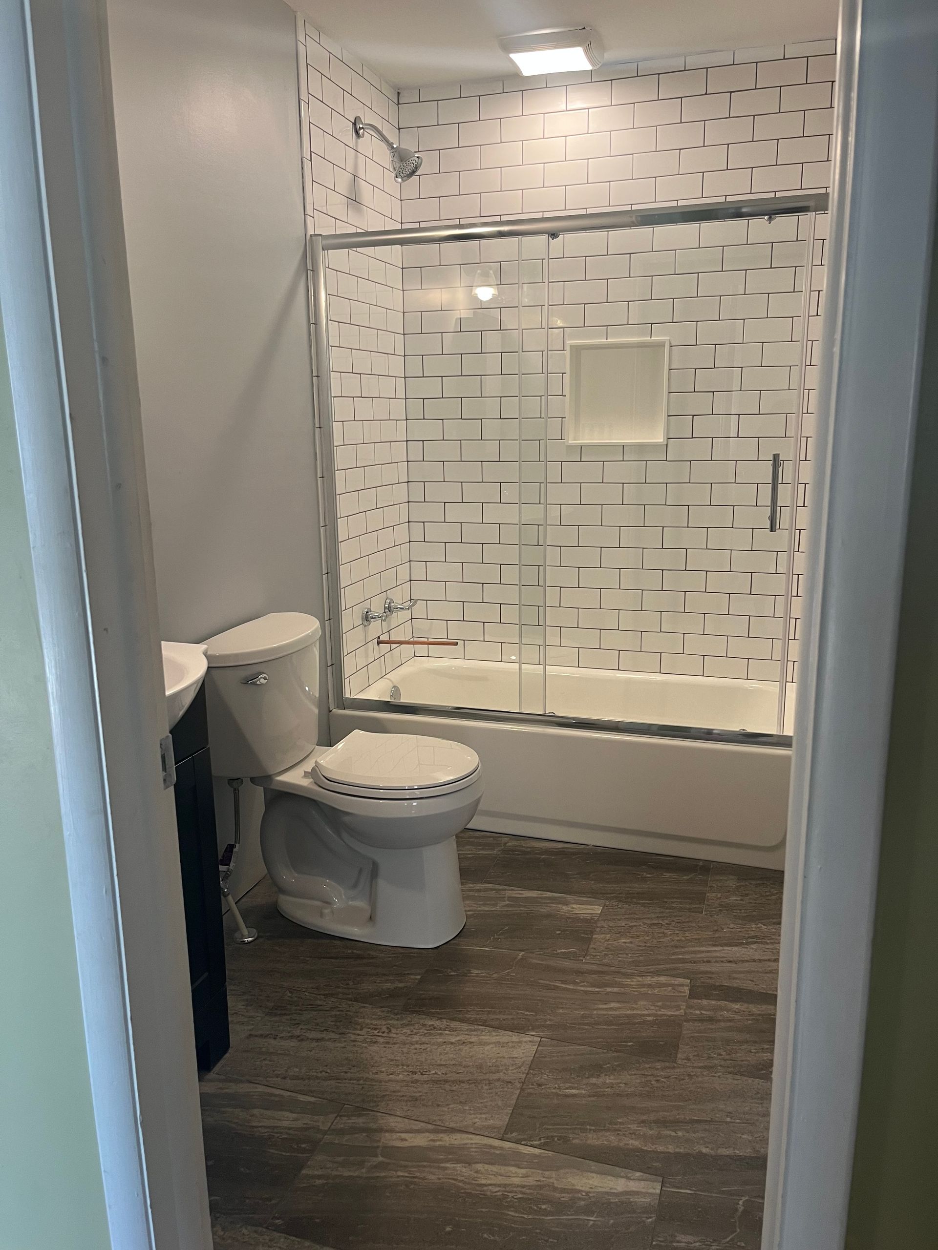 A bathroom with a toilet, sink and bathtub