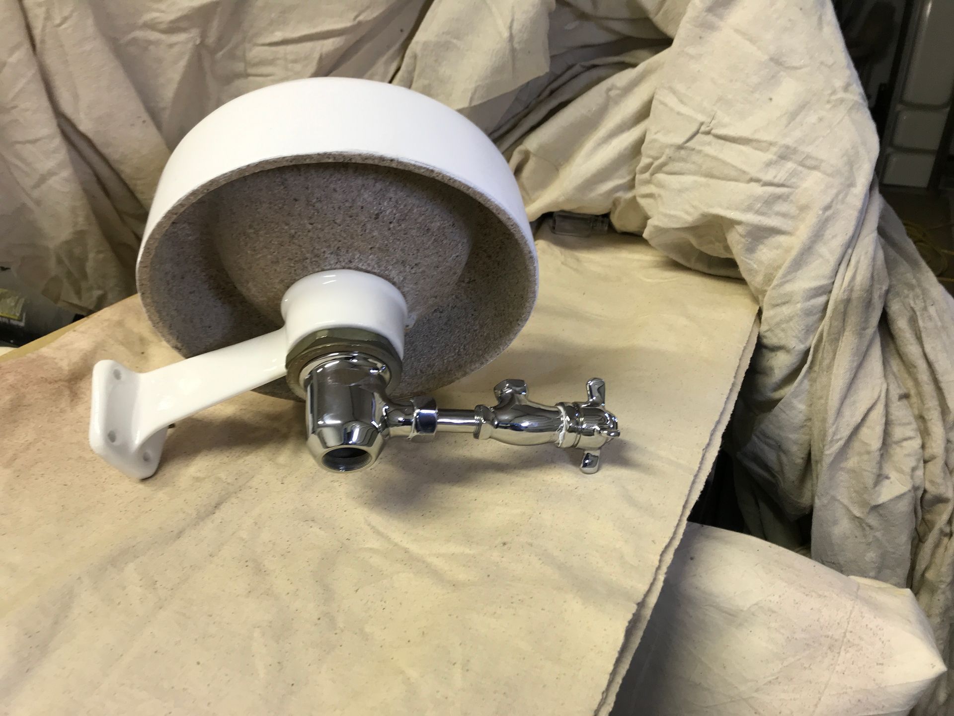 A white soap dish is sitting on a white cloth on a table