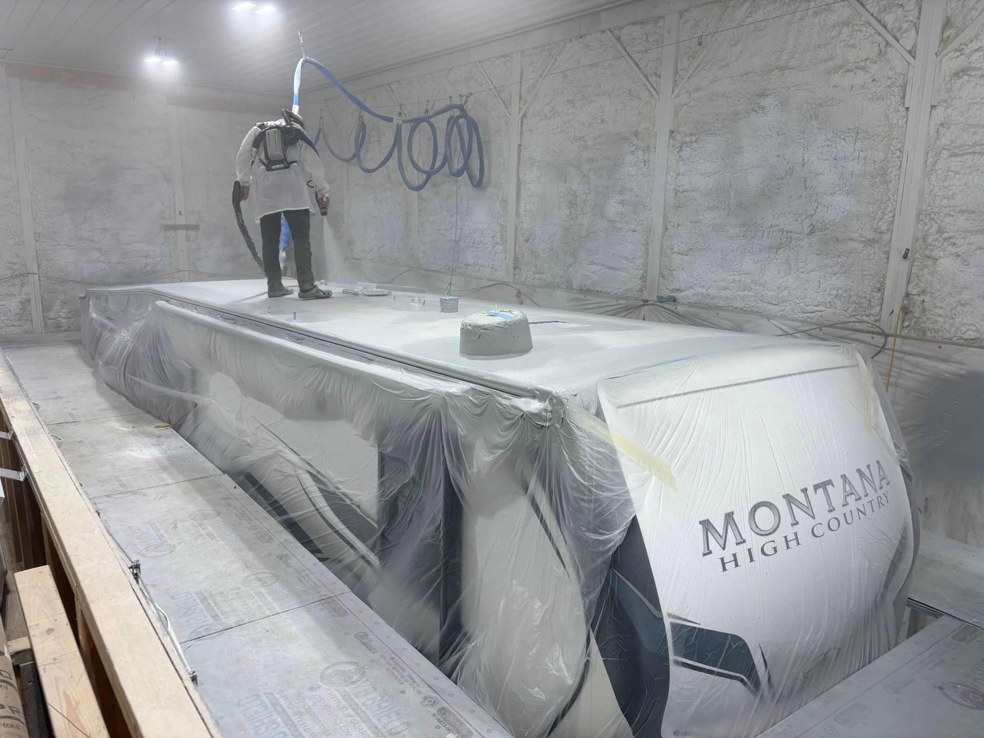 A man is standing on top of a large container in a room.