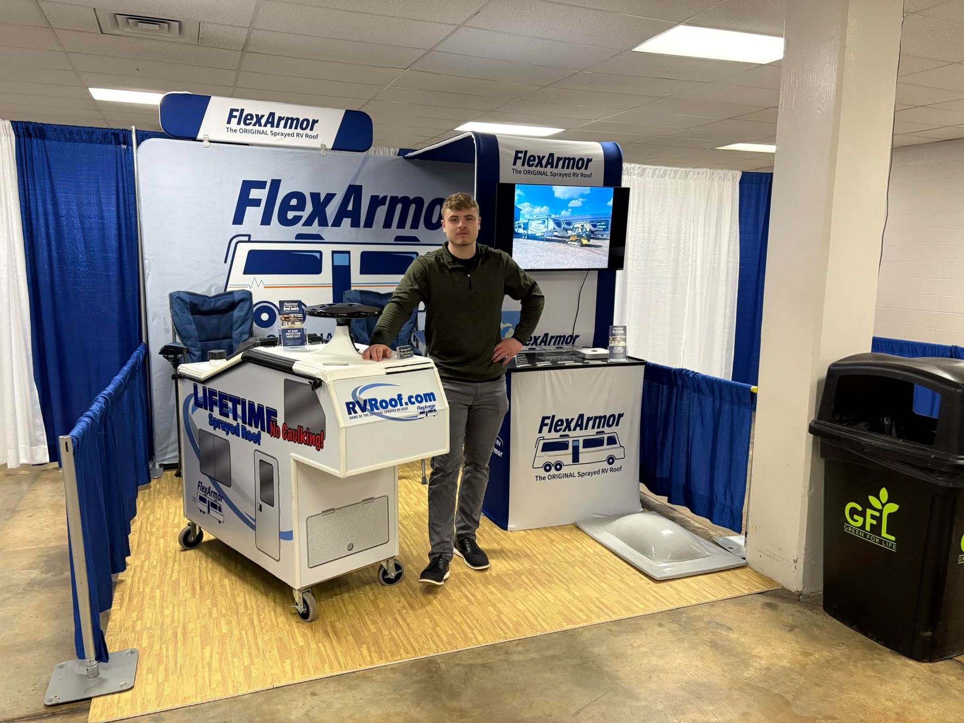 A man is standing in front of a flex arm booth.