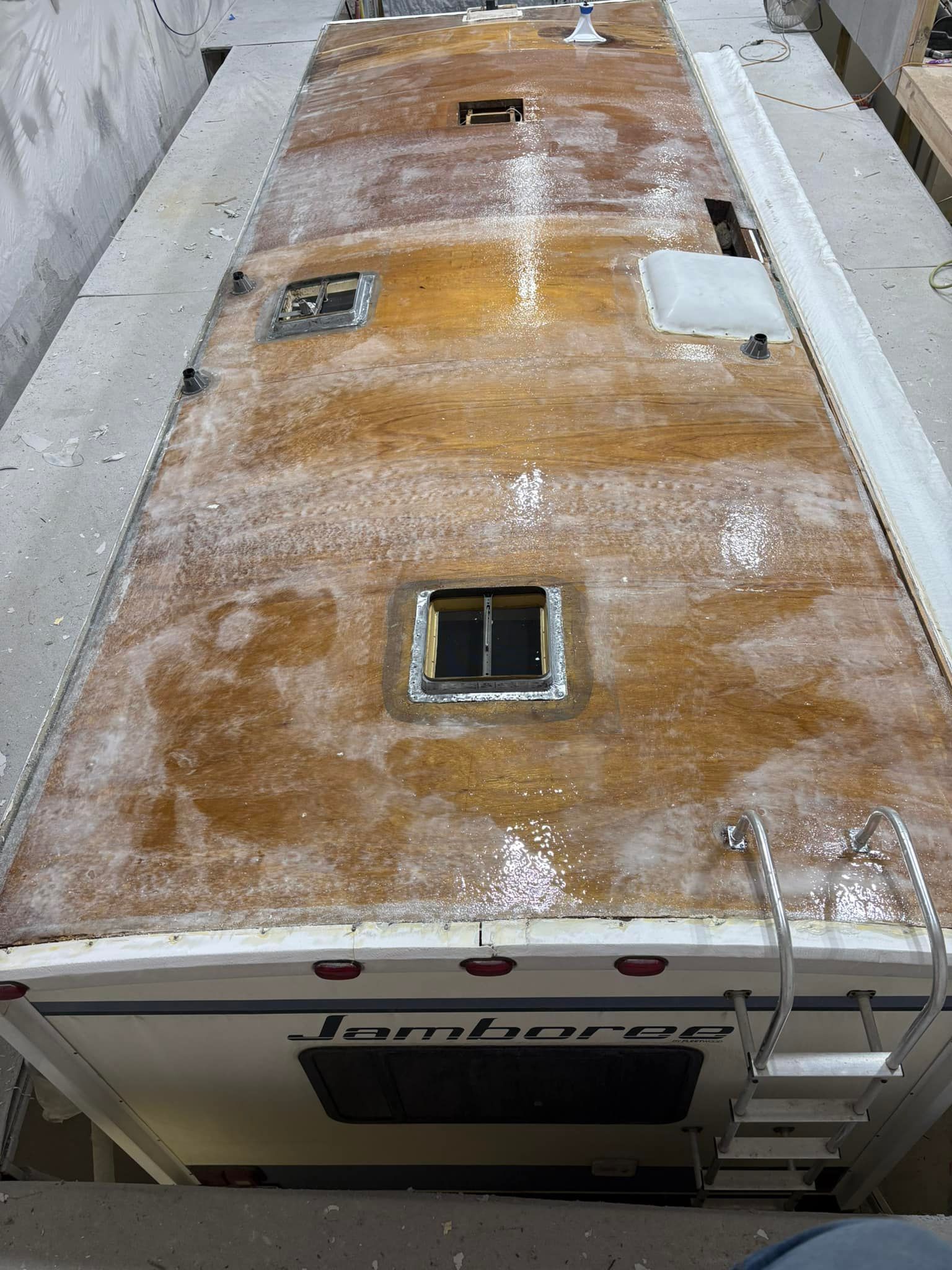 A roof of a camper with a ladder attached to it.