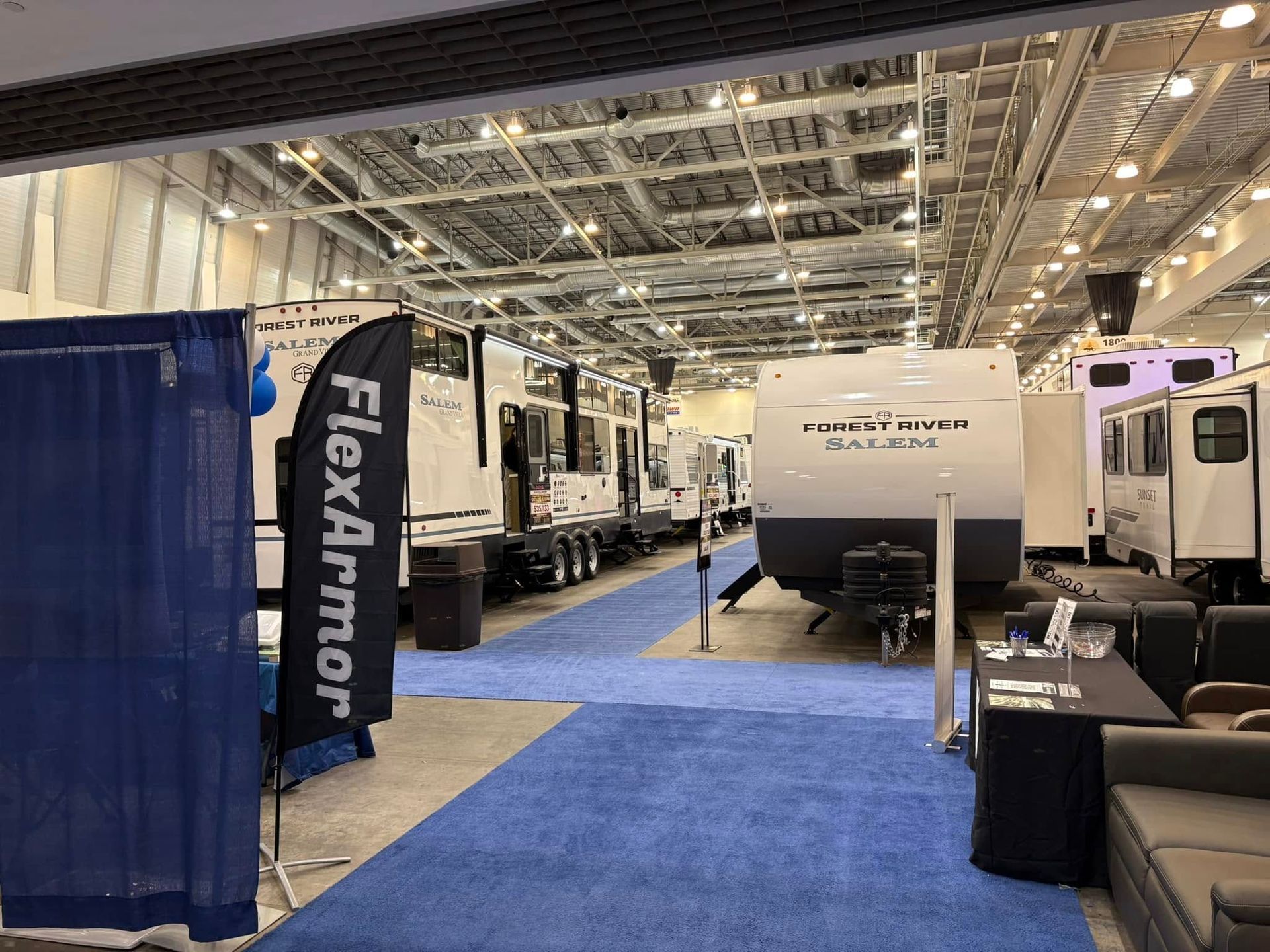 A large room filled with rvs and a flag that says flexarmor.