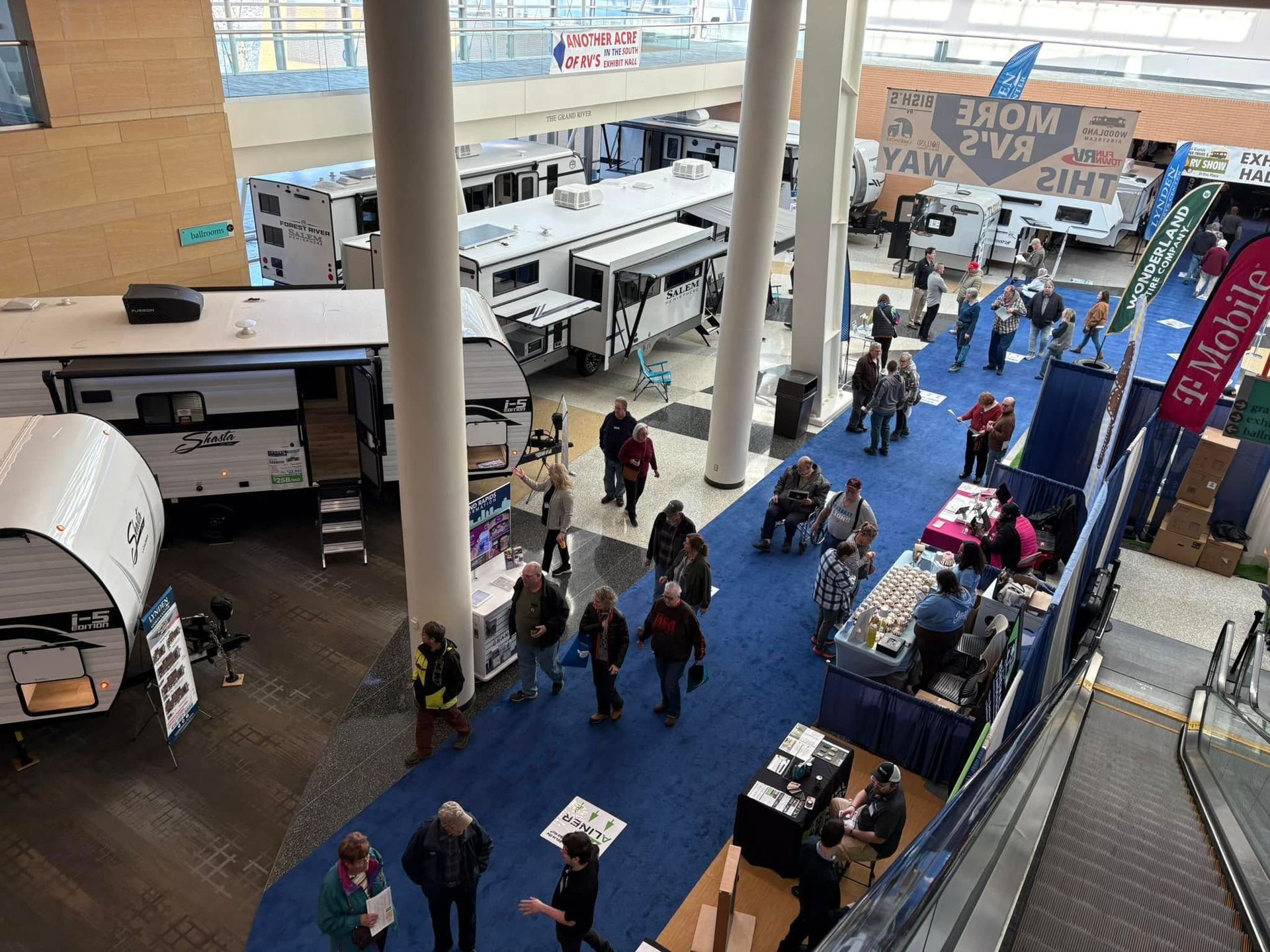 An aerial view of a convention center filled with people and rvs.