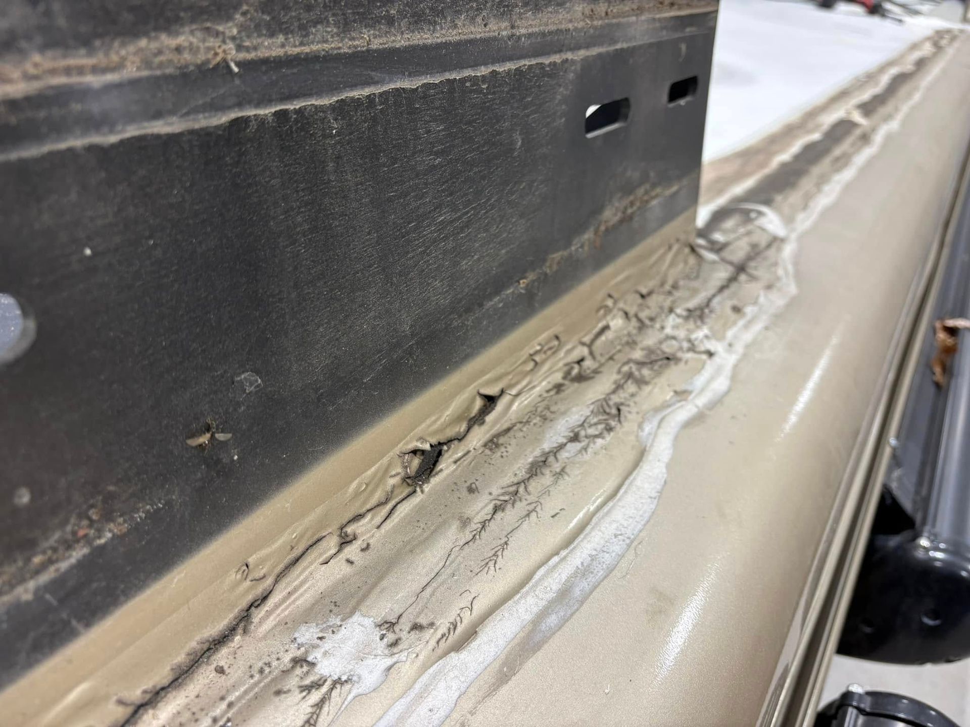 A close up of a piece of metal with a lot of glue on it.