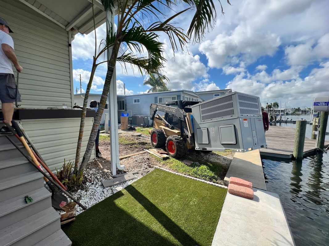 Truck crashed into a building next to a dock. A person stands on steps. Cloudy sky.