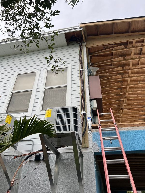 Exterior shot of a building with AC unit, exposed wall, and a ladder.
