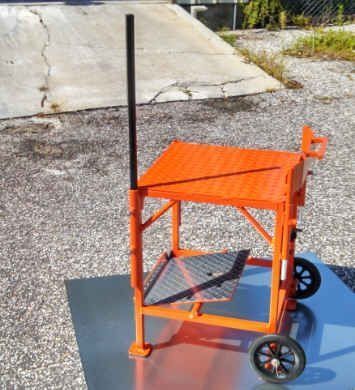 Orange and black wheeled platform, likely for construction, with a tall pole.