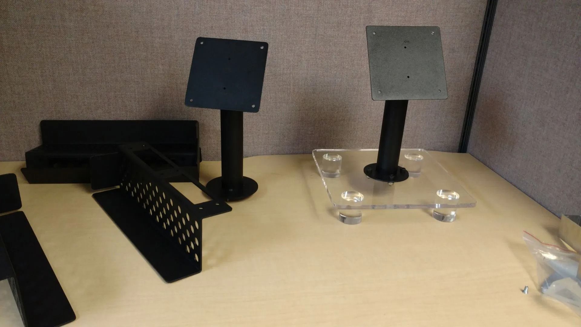 Two black display stands, a black couch, and other black components on a beige surface.