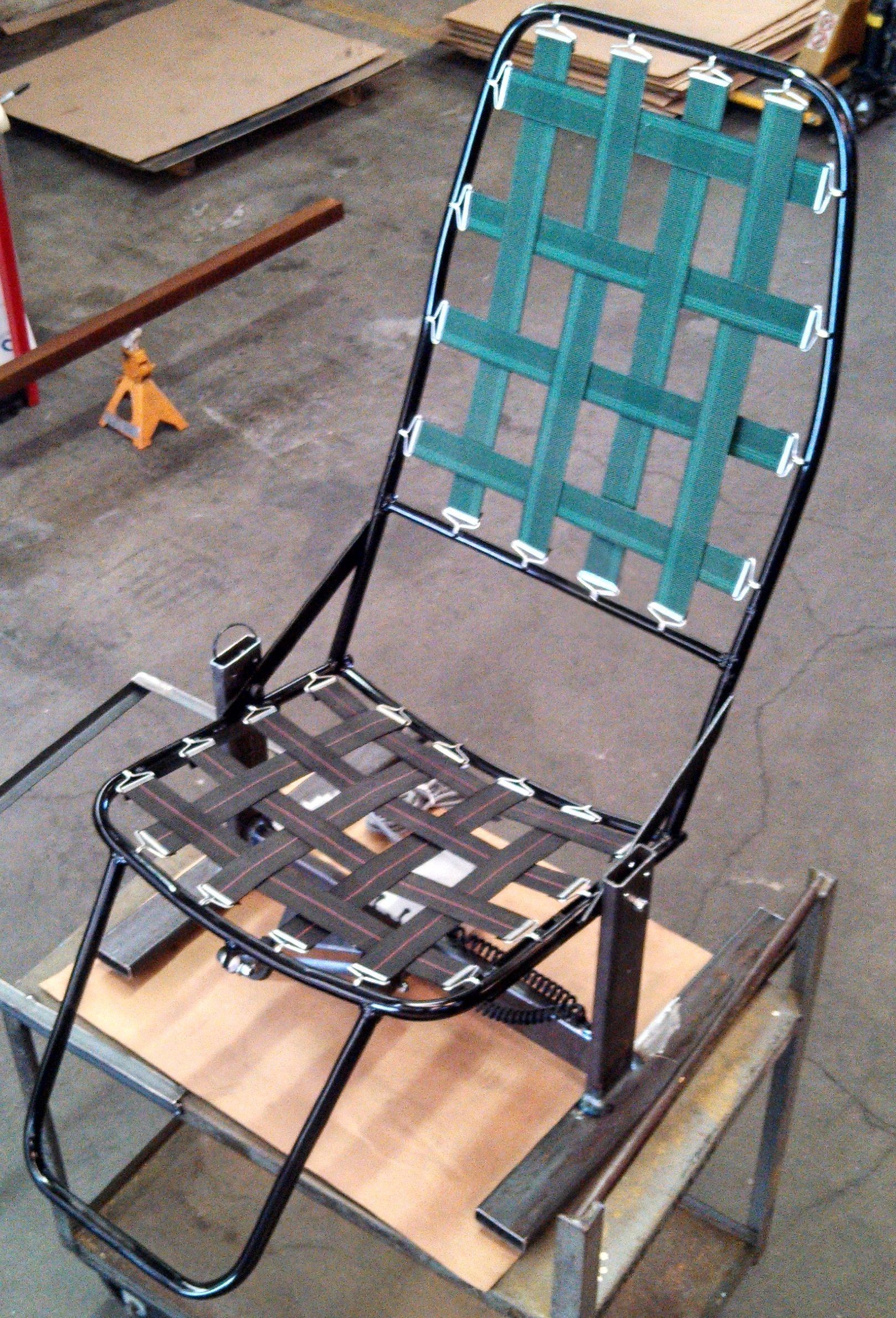 Black metal chair with woven green and black straps, indoors.