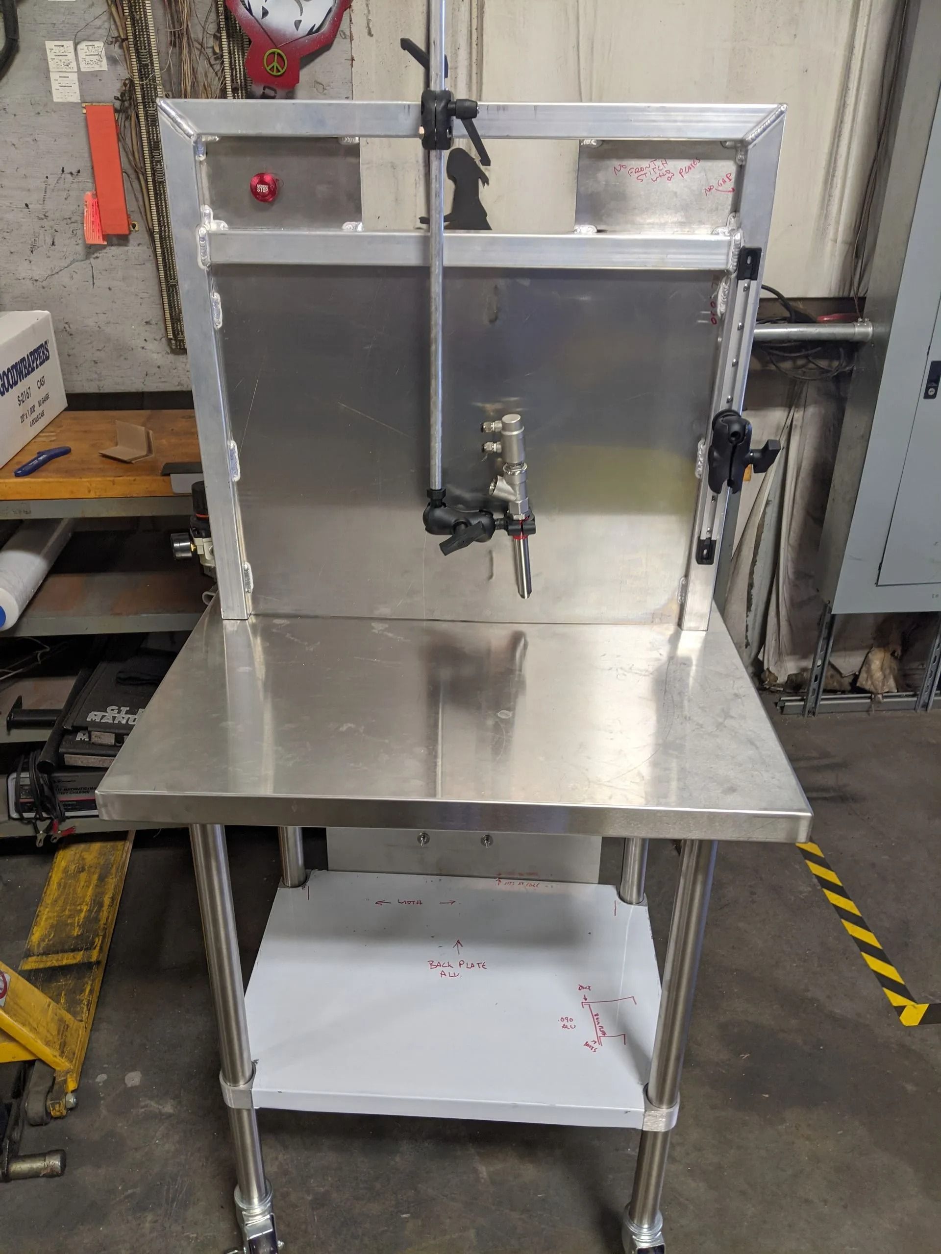Stainless steel work table with a metal back, a faucet, and wheels.