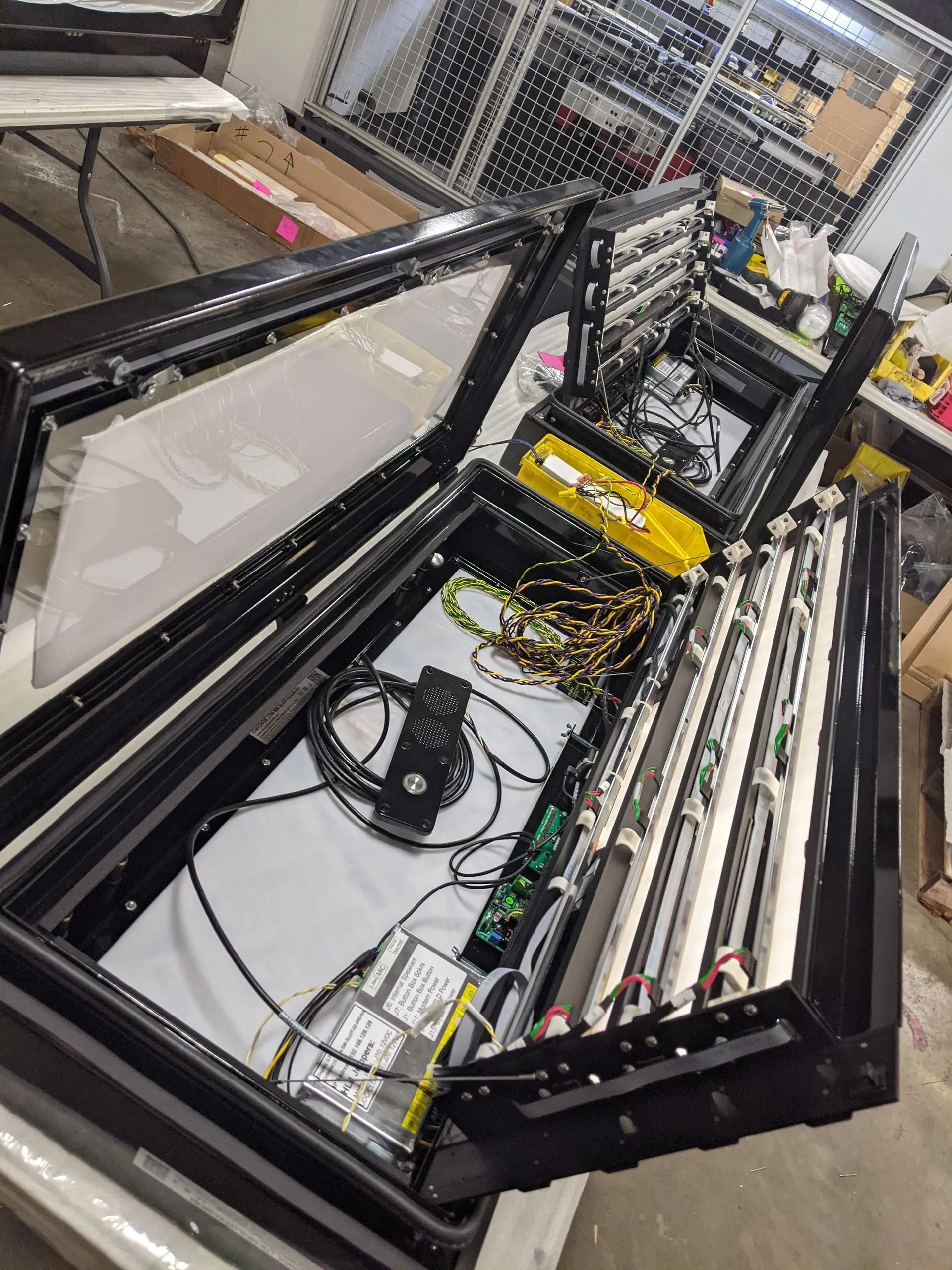 Open black box with internal components, including wires, circuit boards, and lights.