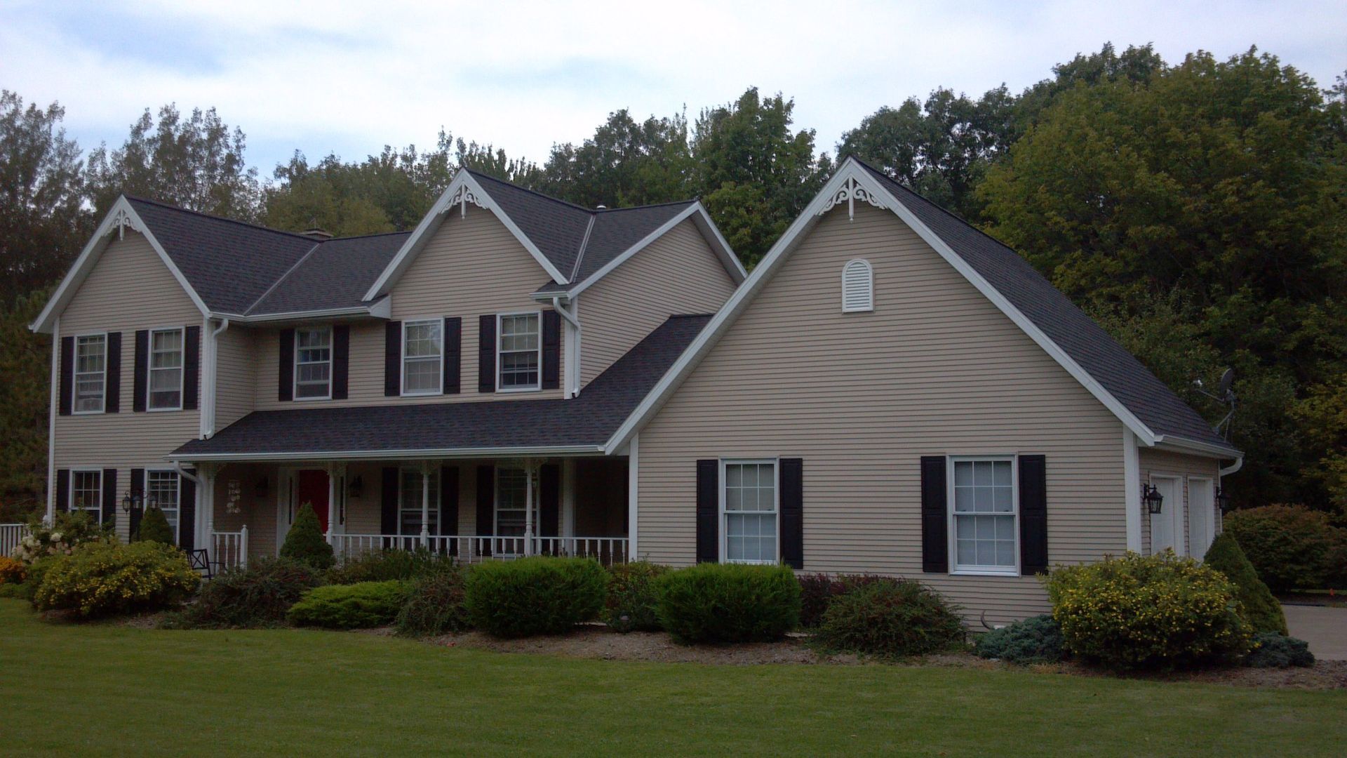 A large house with a black roof and black shutters