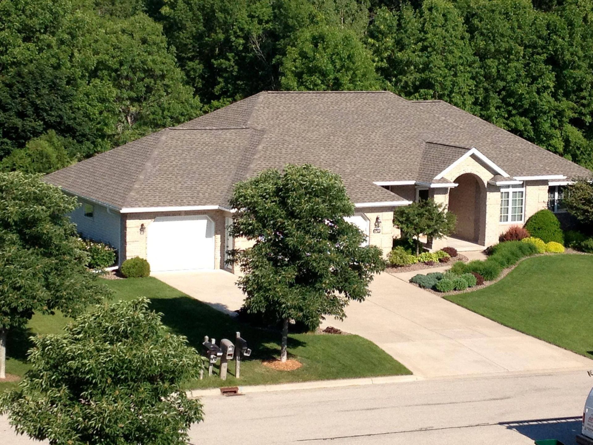 A house with a gray roof and a white garage door